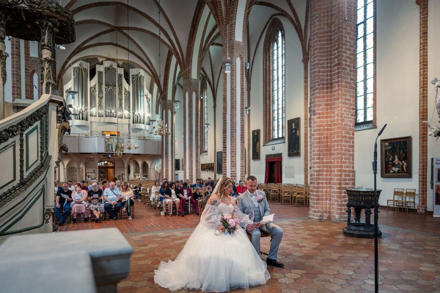 Hochzeit im Spandau, kirchliche Hochzeit St.-Nikolai-Kirche, Brautpaar sitzt gemeinsam während der Zeremonie