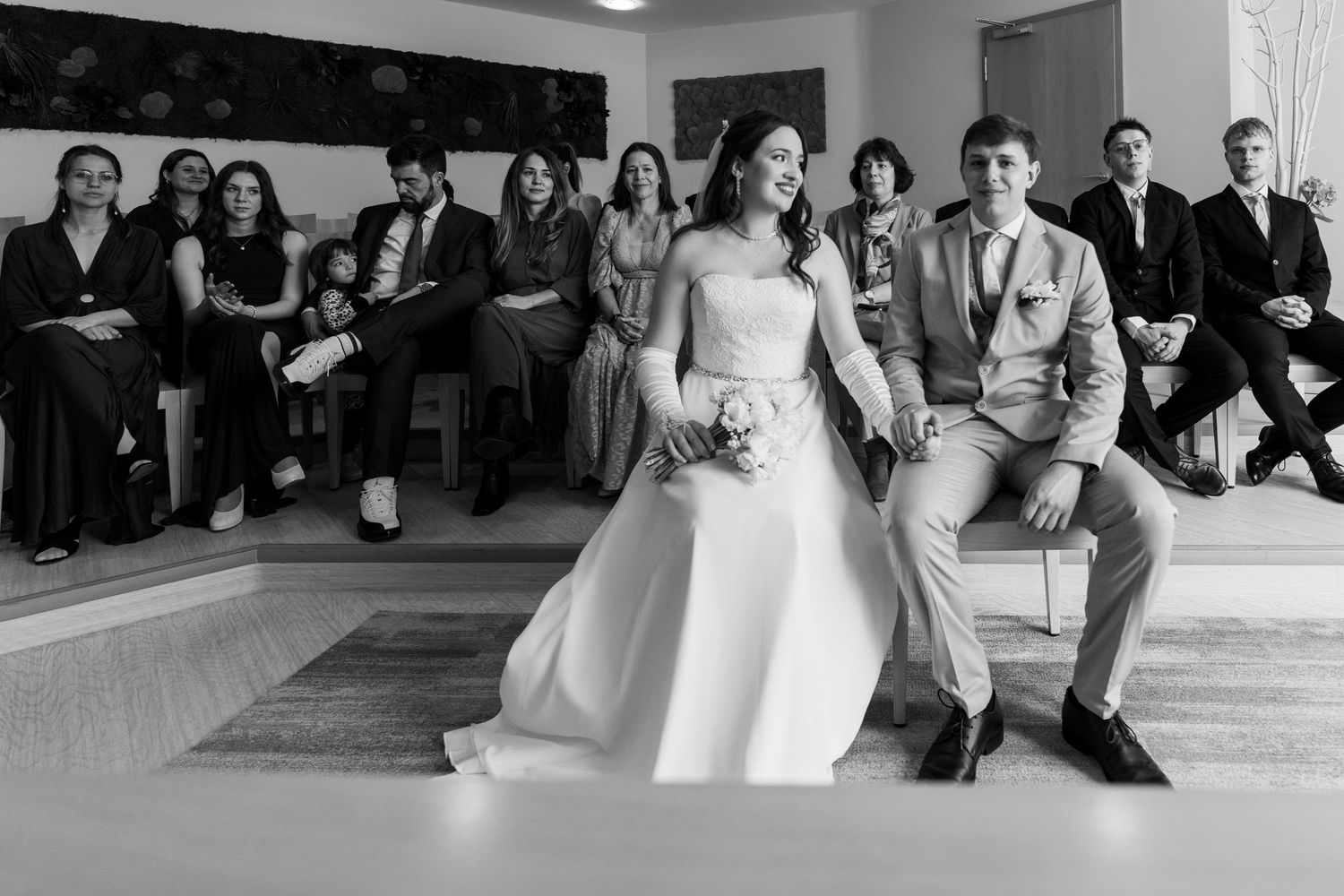 Hochzeit im Standesamt Marzahn Hellersdorf, Brautpaar sitzt gemeinsam vor den Gästen während der Zeremonie
