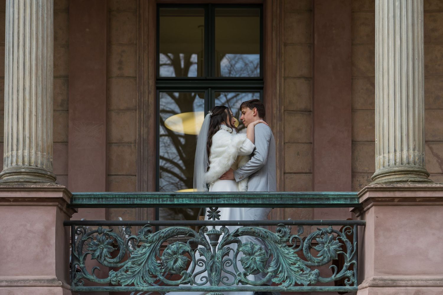 Brautpaar auf dem Balkon von Schloss Biesdorf Berlin, inniger Moment vor historischer Kulisse