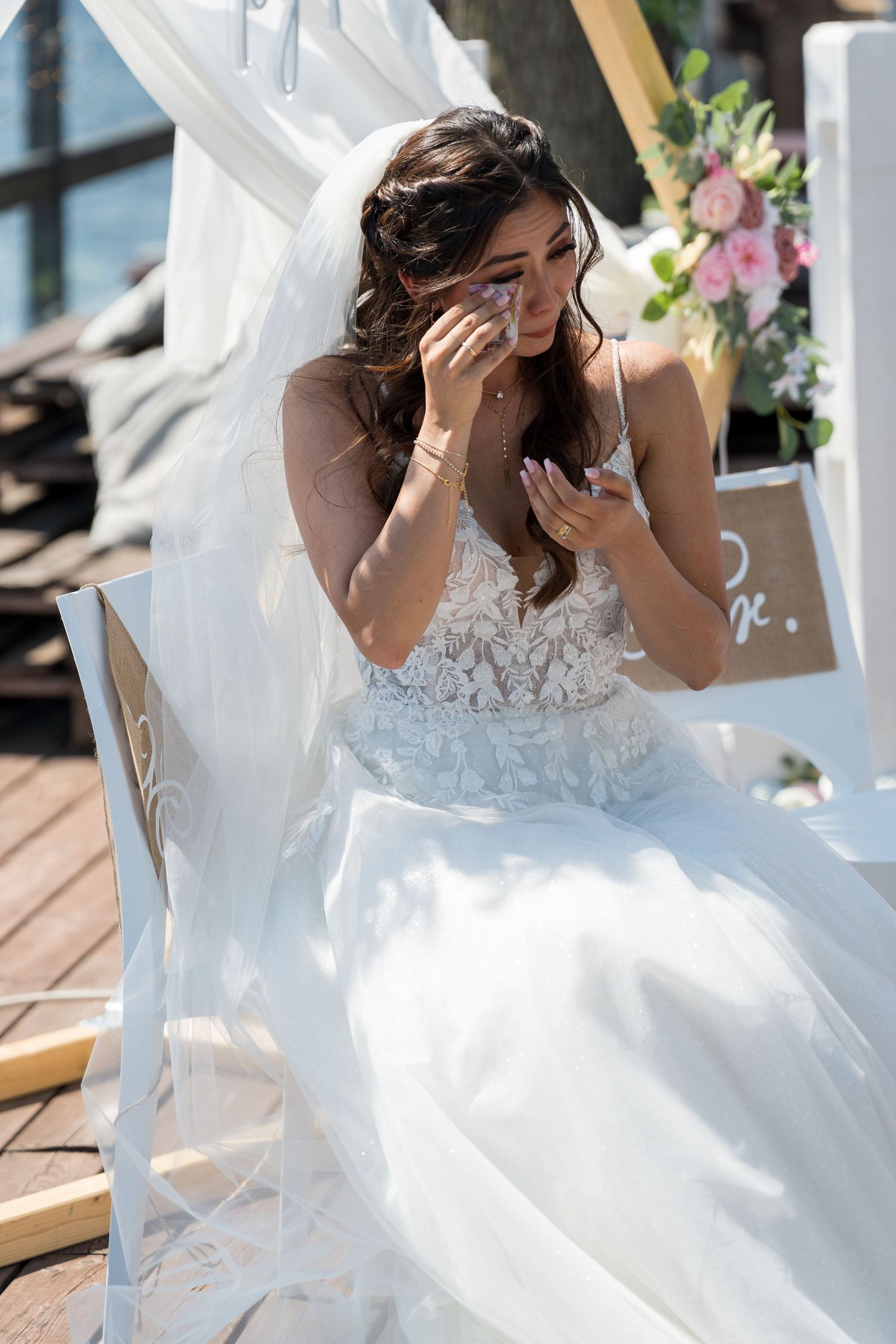 Freie Trauung an der White Spreelounge Berlin, emotionale Braut sitzt lächelnd während der Zeremonie, begleitet von einer Hochzeitsfotografi