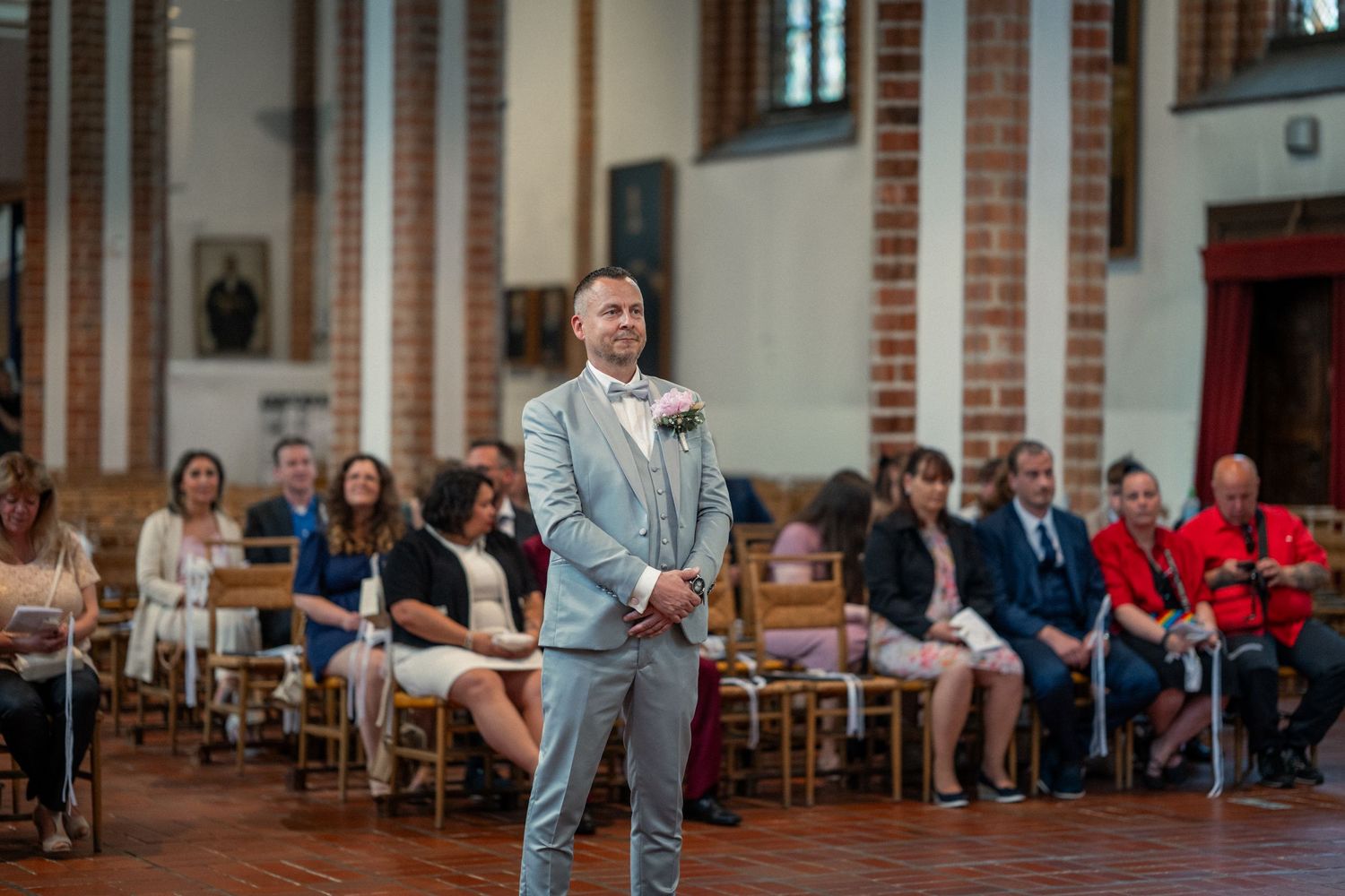 Hochzeit im Spandau, kirchliche Hochzeit St.-Nikolai-Kirche, Bräutigam steht lächelnd vor den Gästen