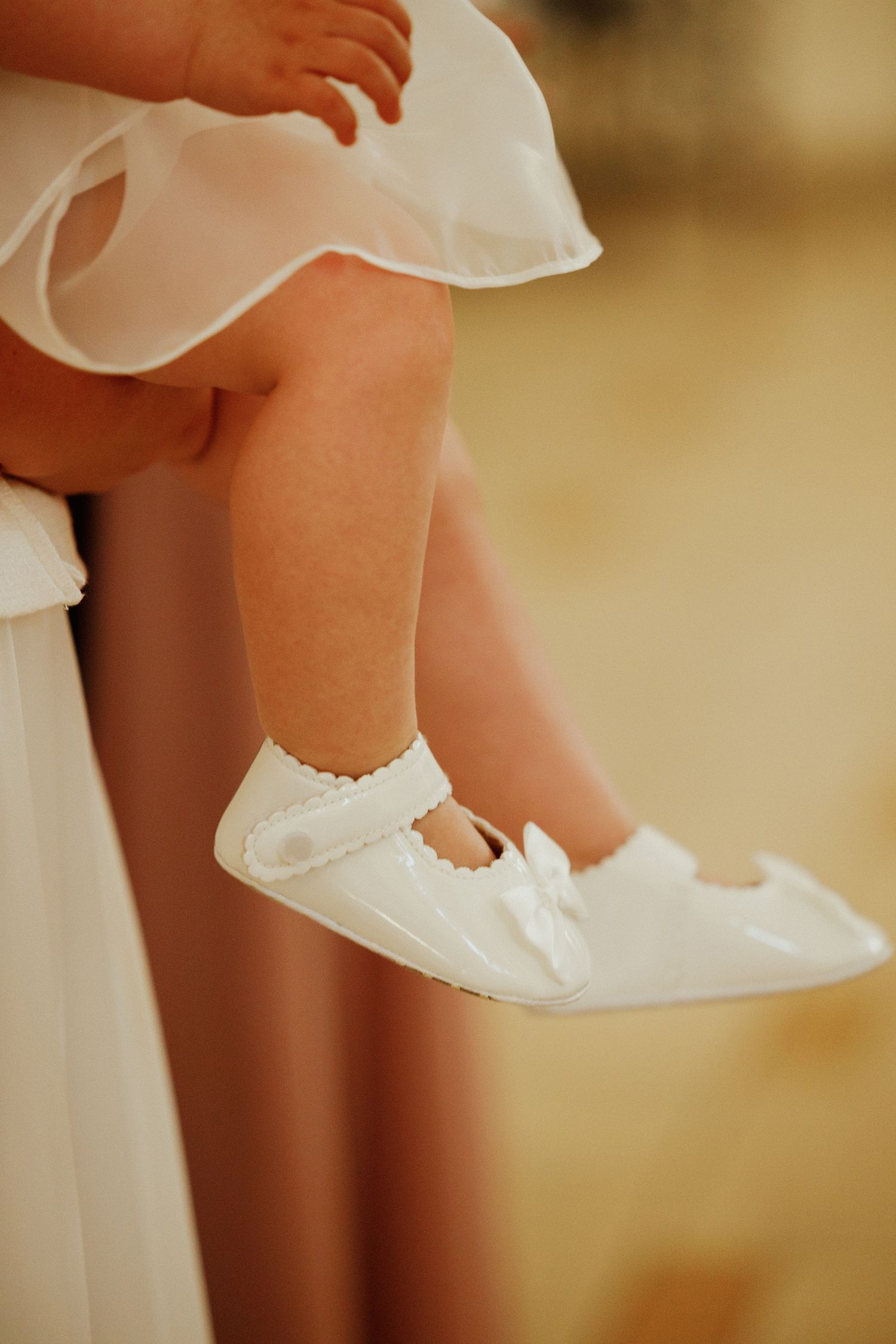 Detail shots of white ballet flats or dress shoes against a soft beige background.