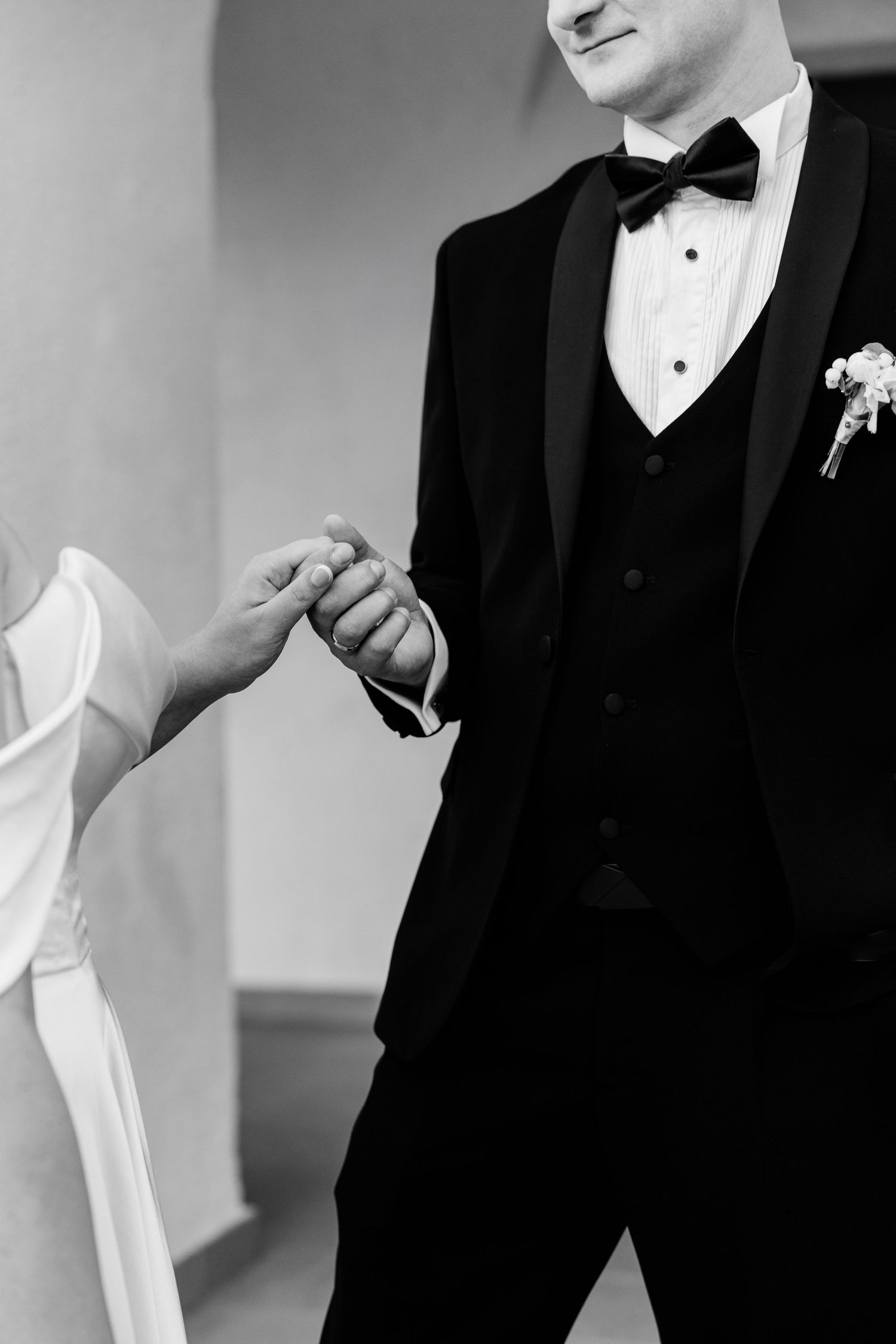 Detail shots of groom in classic black tuxedo with white boutonniere.