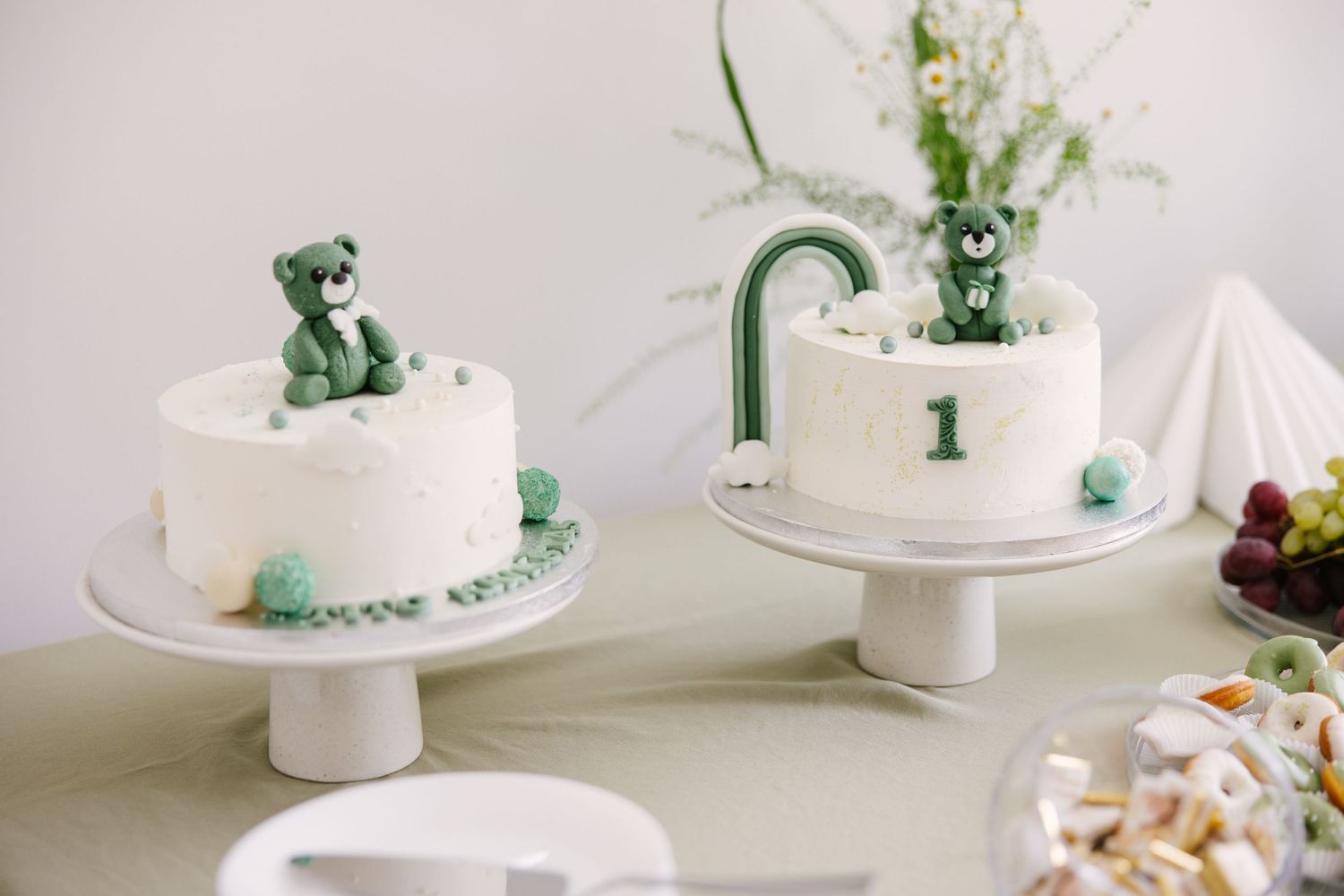 White tiered cakes decorated with delicate green accents and floral designs.