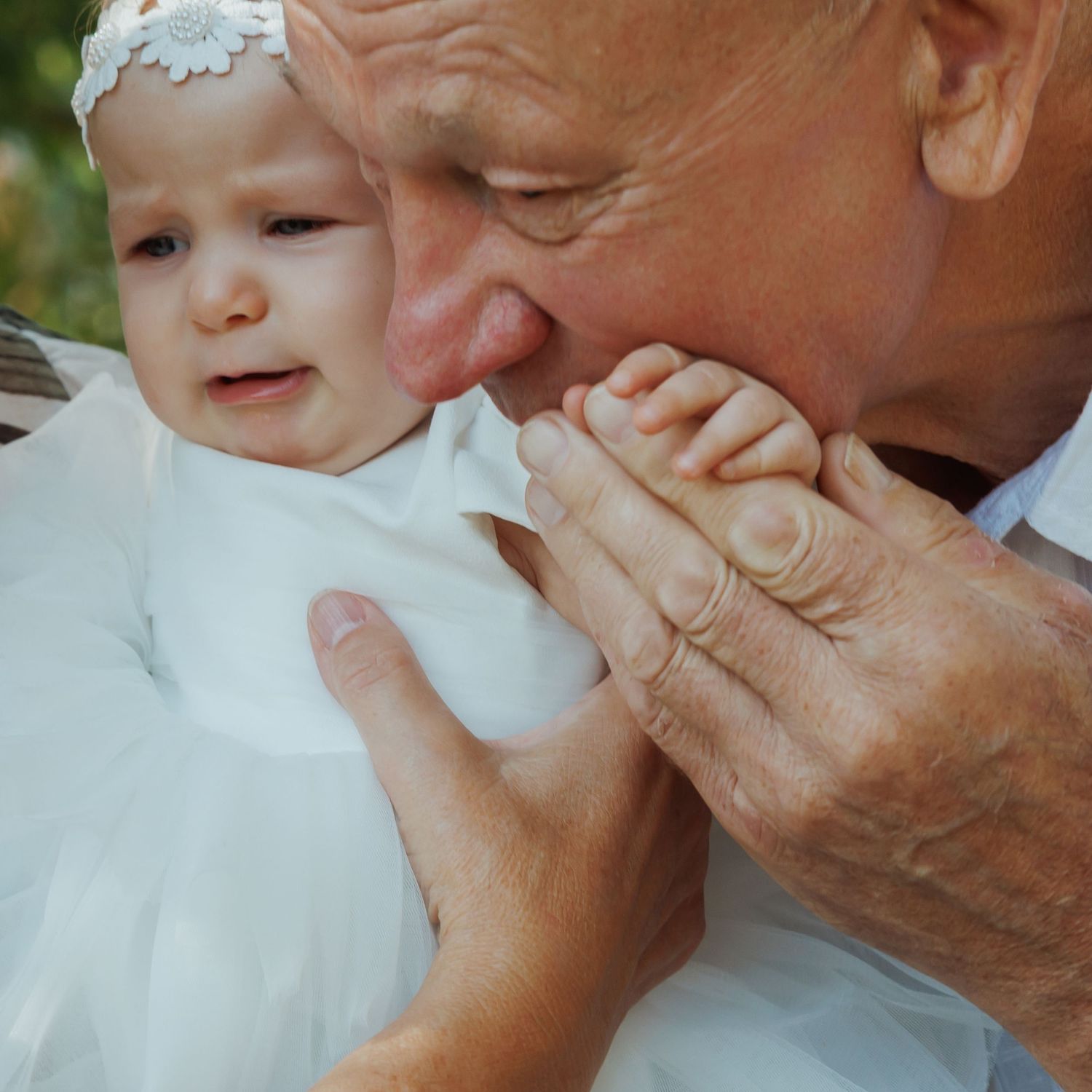 Close-up sequence showing a tender moment between a baby and adult hand in natural lighting.