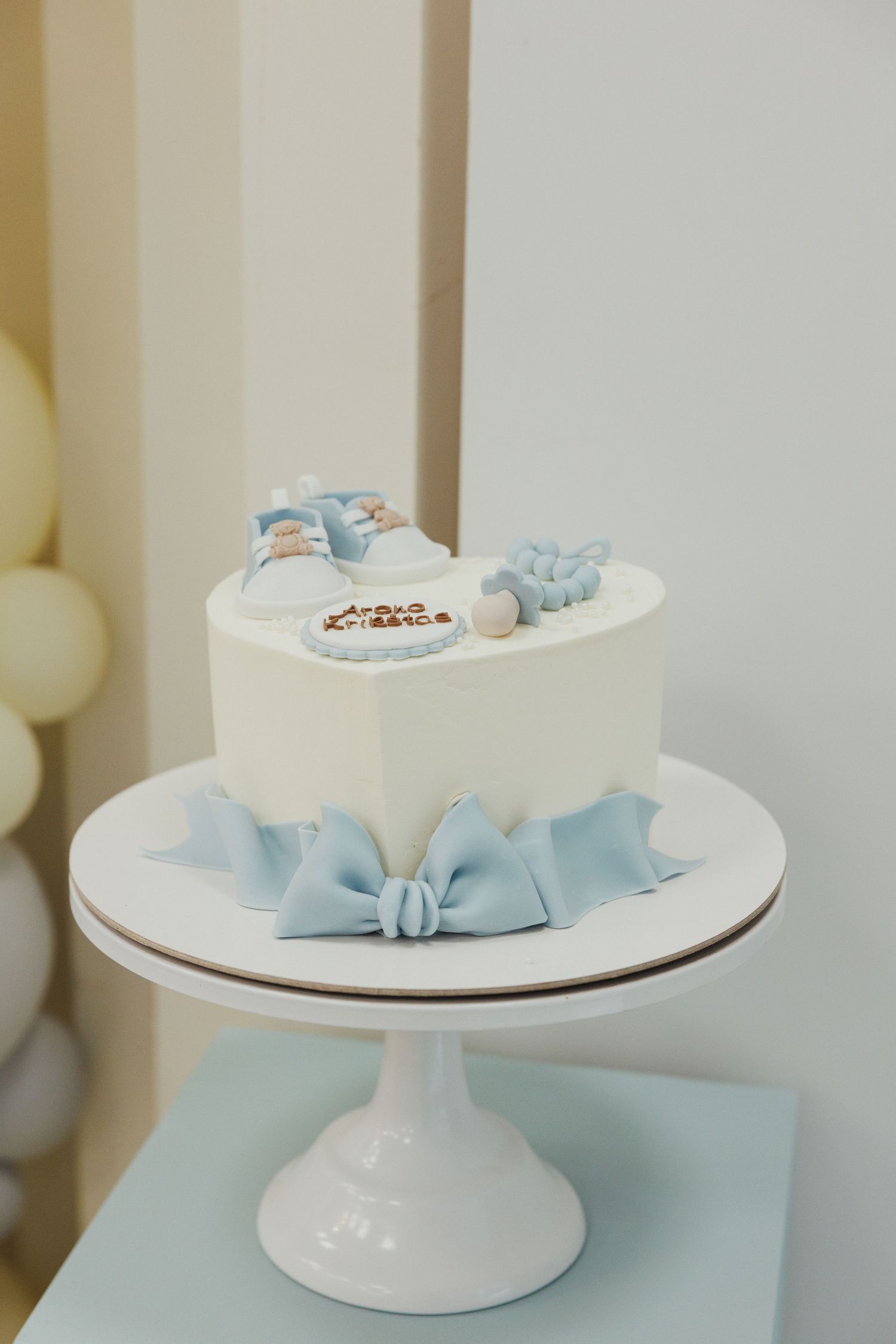 White cake stands decorated with light blue ribbons and small decorative elements.
