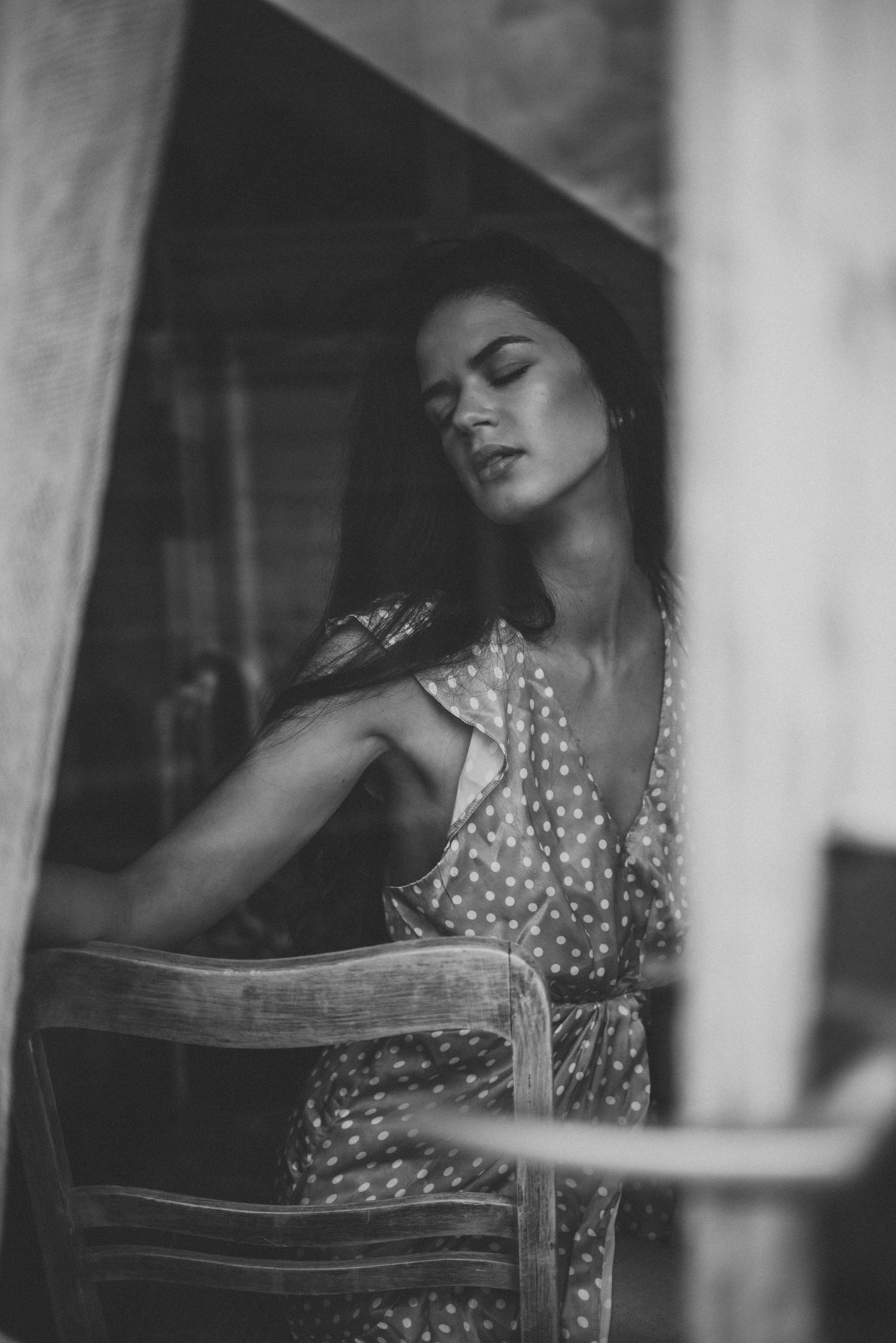 Black and white portrait showing ethereal mood through window light.