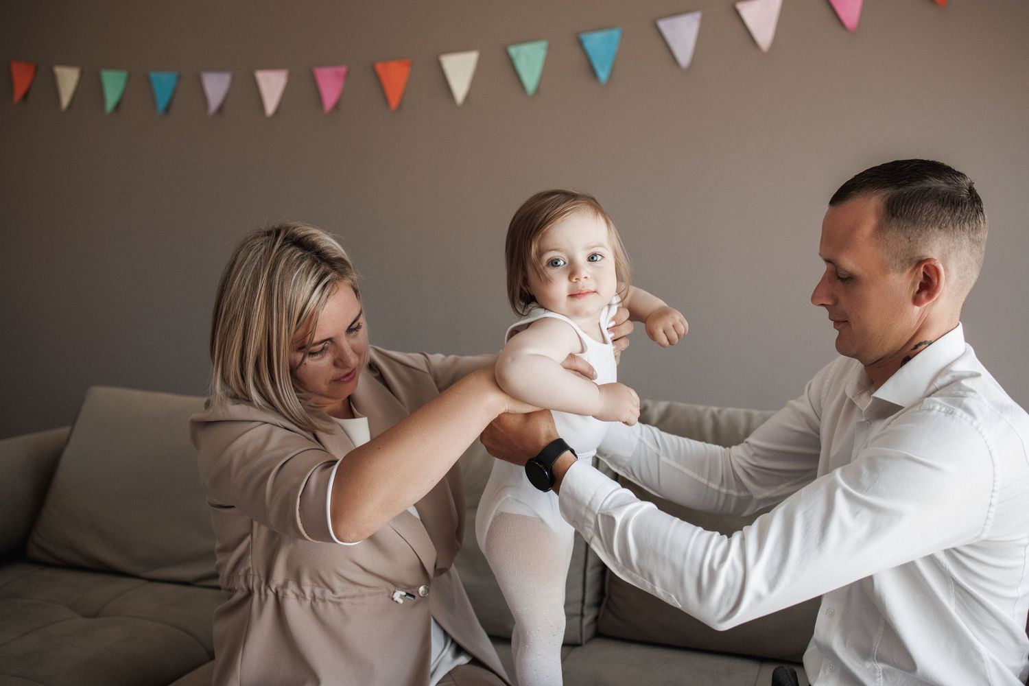 A couple dances together under colorful bunting flags at a celebration.