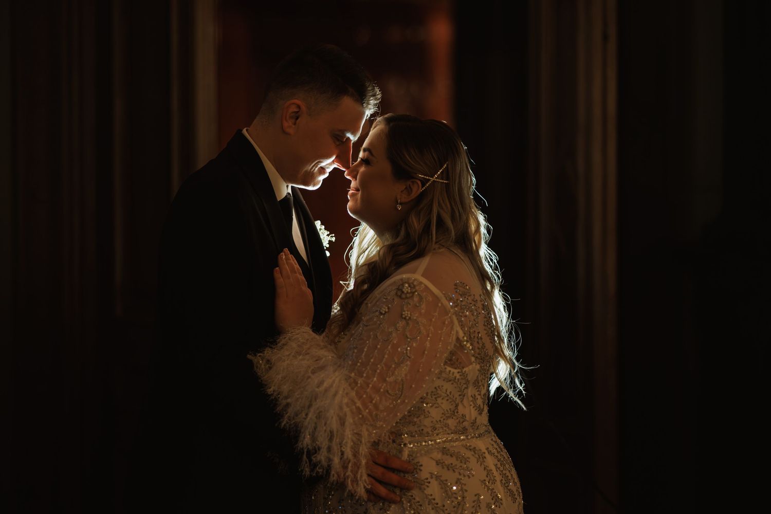 Dramatic silhouette wedding photos in dark setting.