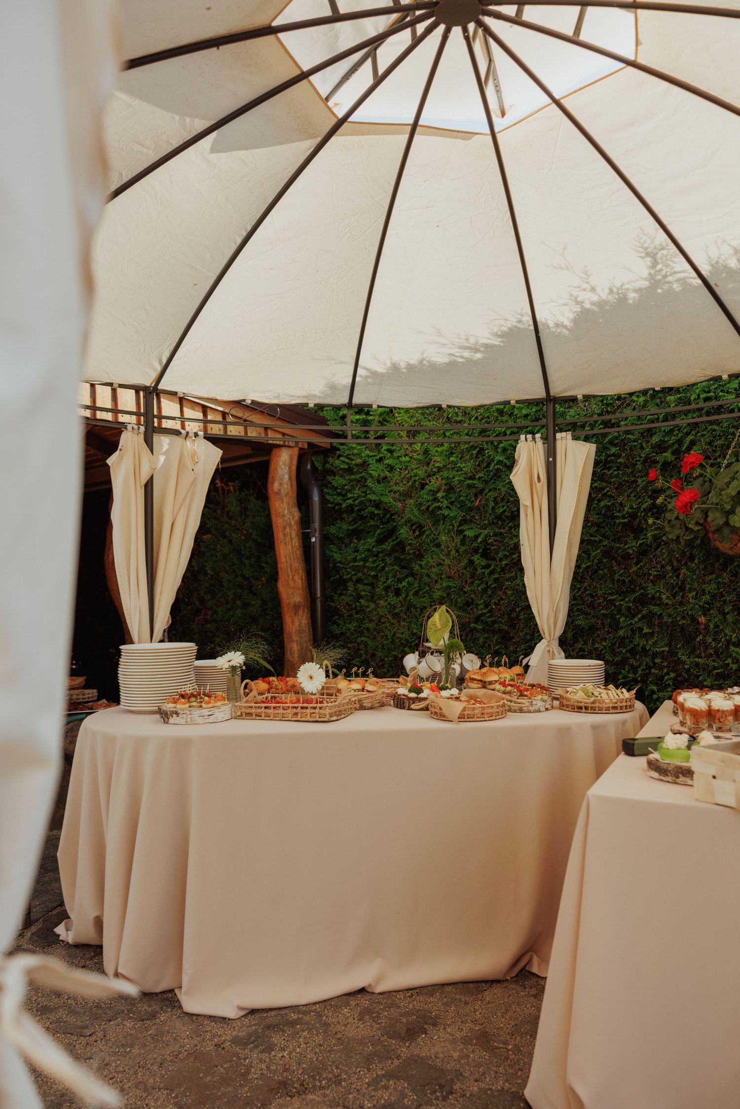White canopy tent with elegant table settings and floral arrangements for an outdoor reception.