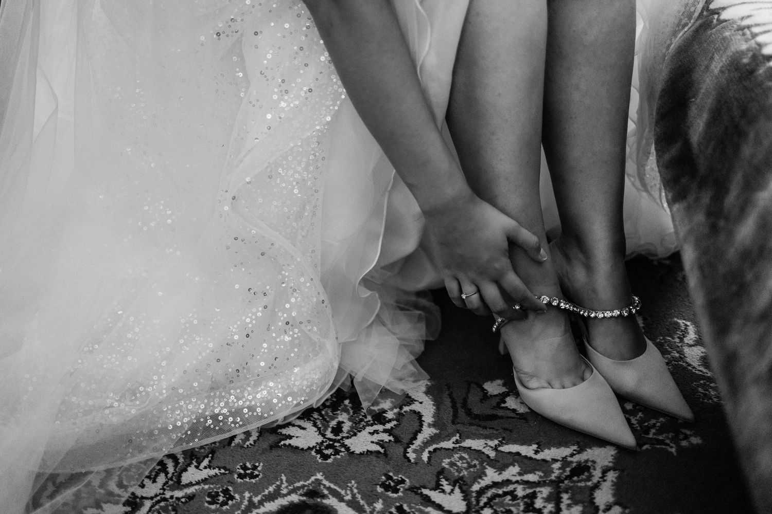 Close-up details of delicate lace and beading on white formal attire.