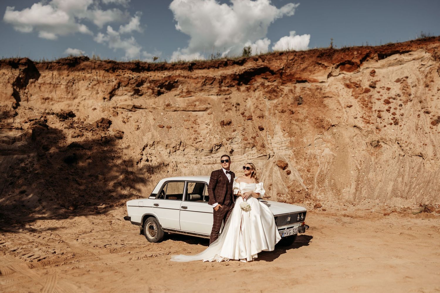 A panoramic view of a desert landscape with cliffs and a vintage car in a wedding setting.