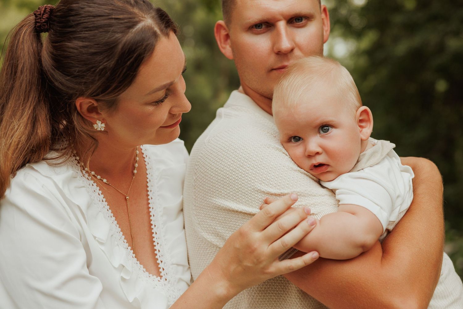 An outdoor portrait series showing gentle interactions between parent and baby against a natural background.