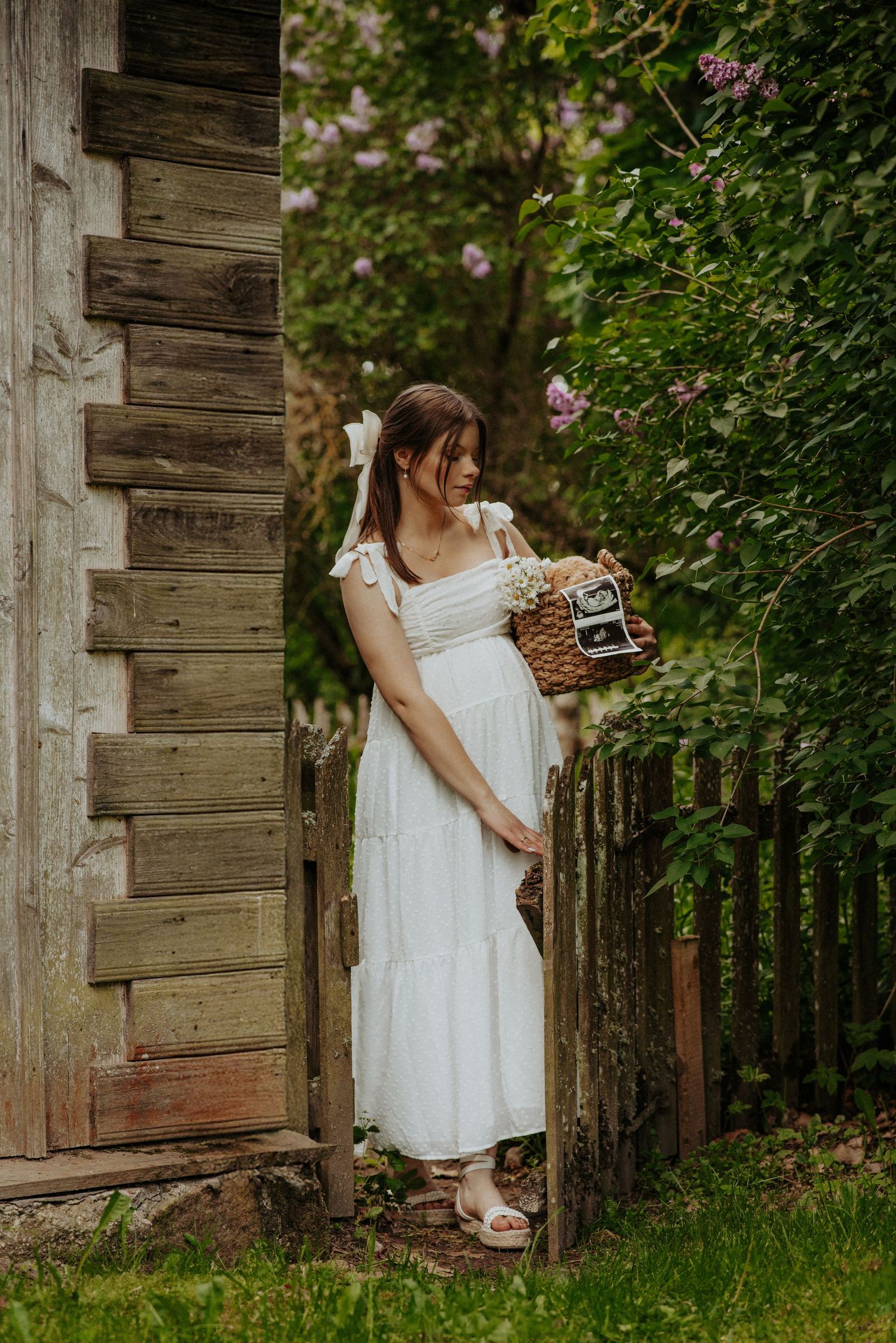 Rustic maternity photography session at weathered wooden cabin with vintage elements.