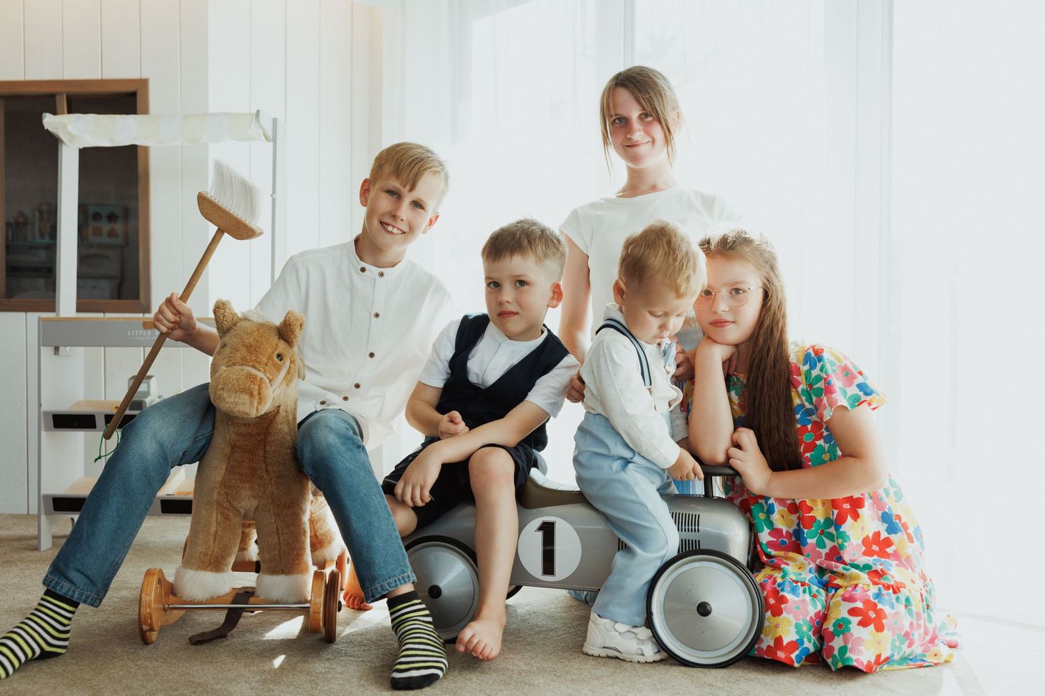 Four connected images showing children playing with wooden toys and blocks on a light colored floor.
