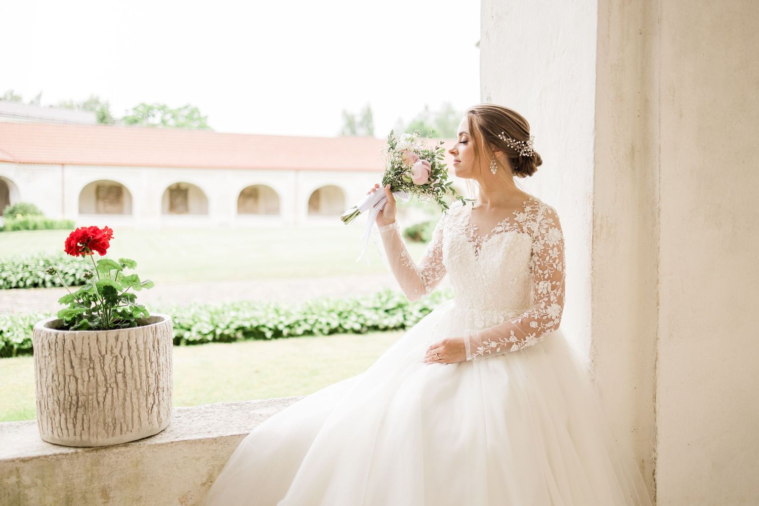 Elegant wedding portraits in white colonnade with garden scenery and floral details.