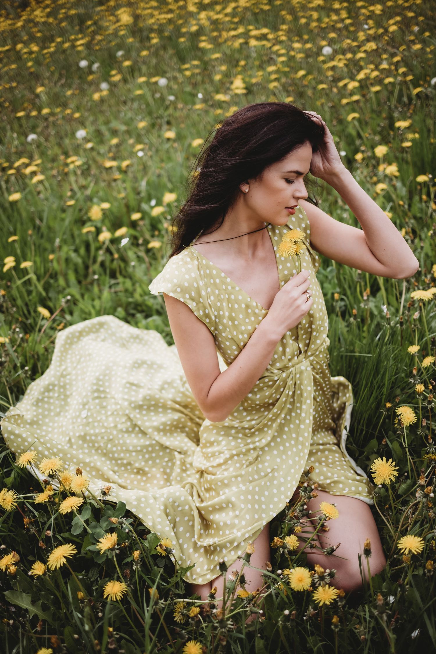 Dreamy portrait series in yellow dress amid field of blooming dandelions.