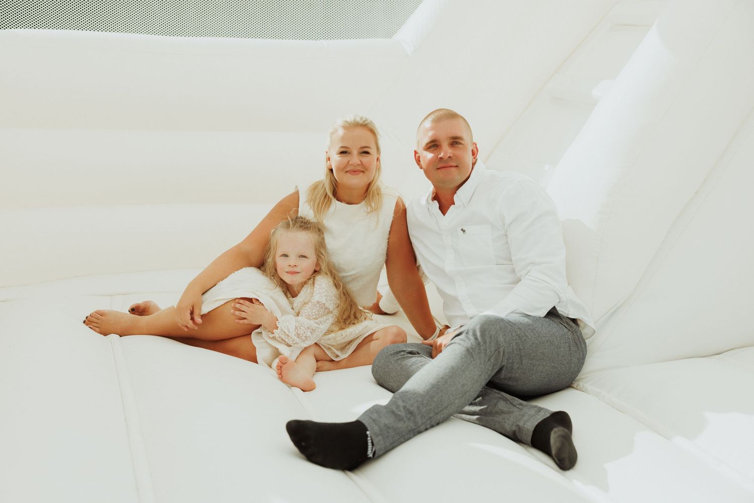 Family portrait session on white background showing casual relaxed poses.