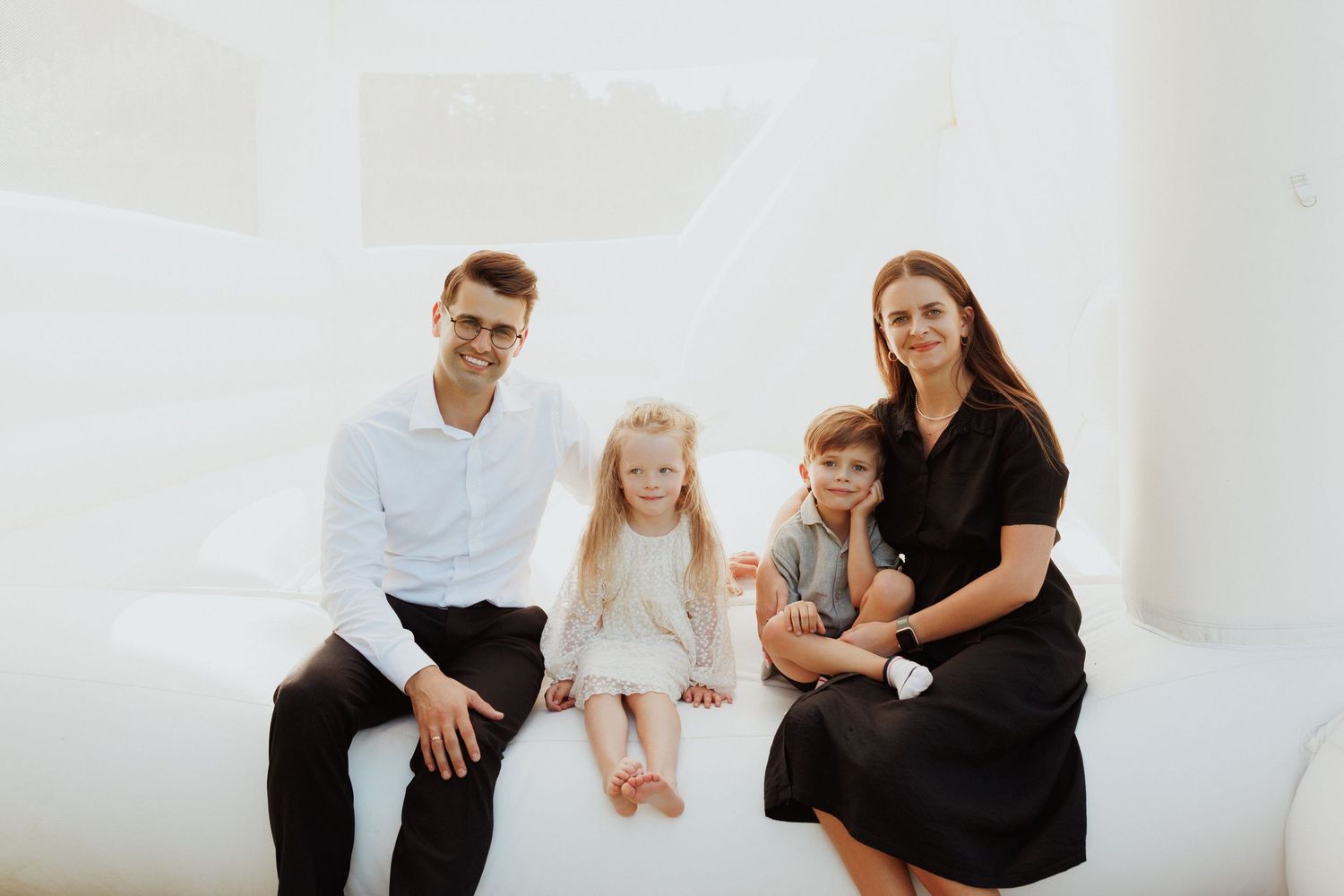 Group portrait in a minimalist white room setting.