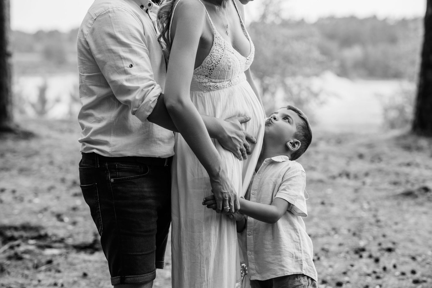 Black and white family photoshoot capturing intimate moments outdoors.