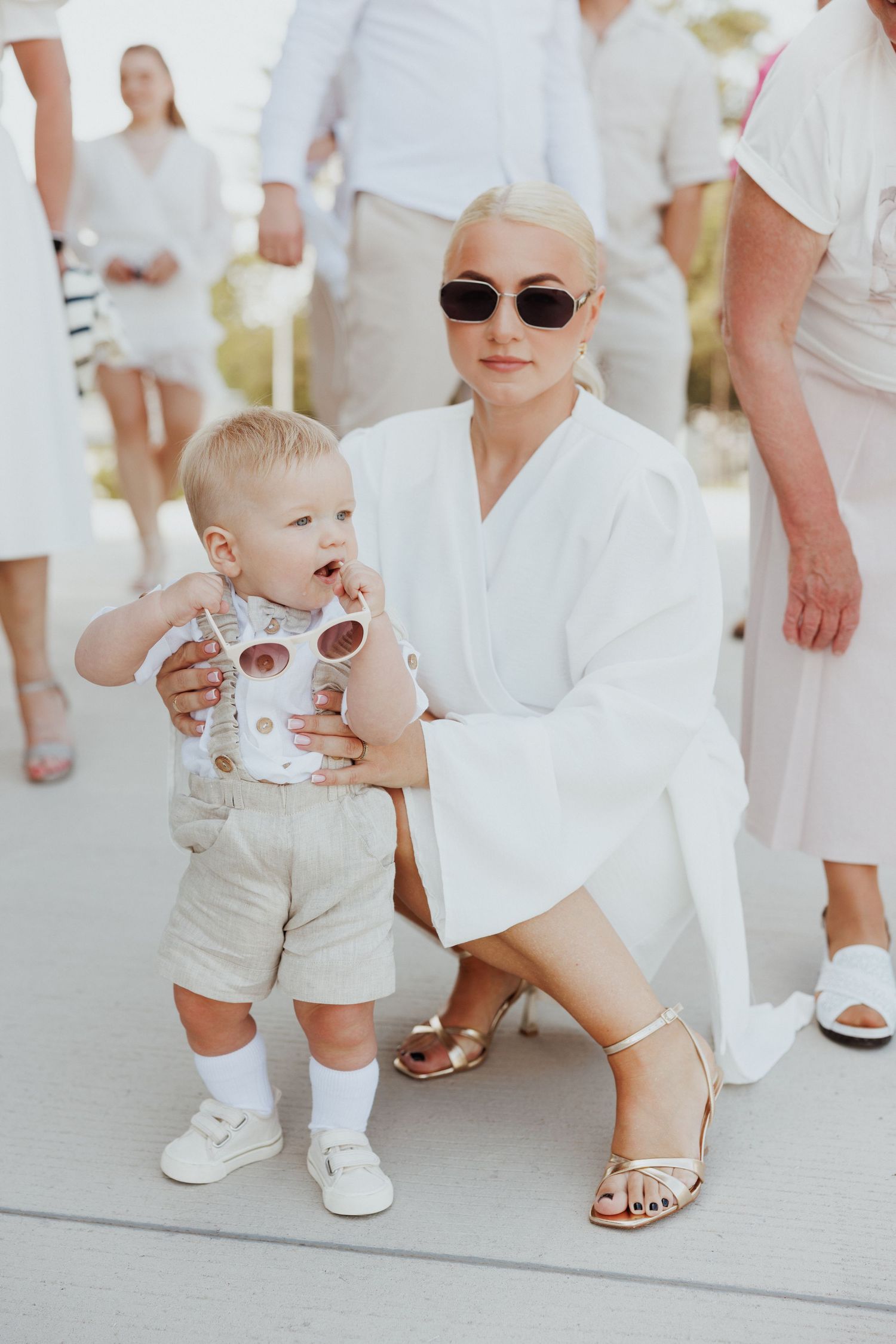 People dressed in all white outfits walking together at a summer event.