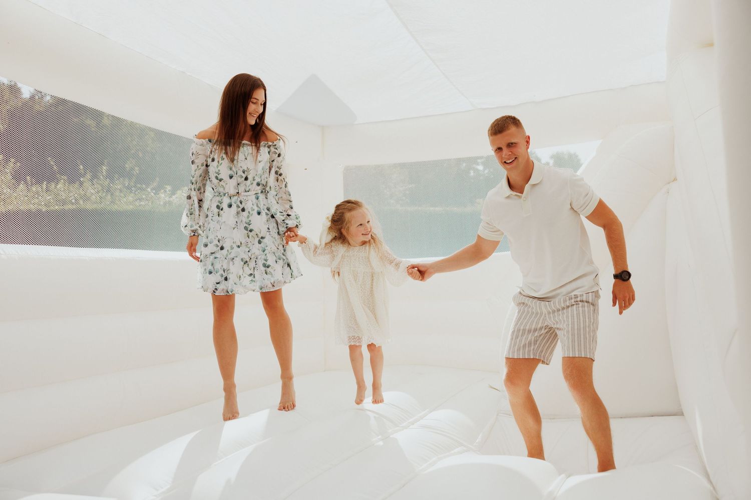 Family enjoying time together on a white bouncy surface.