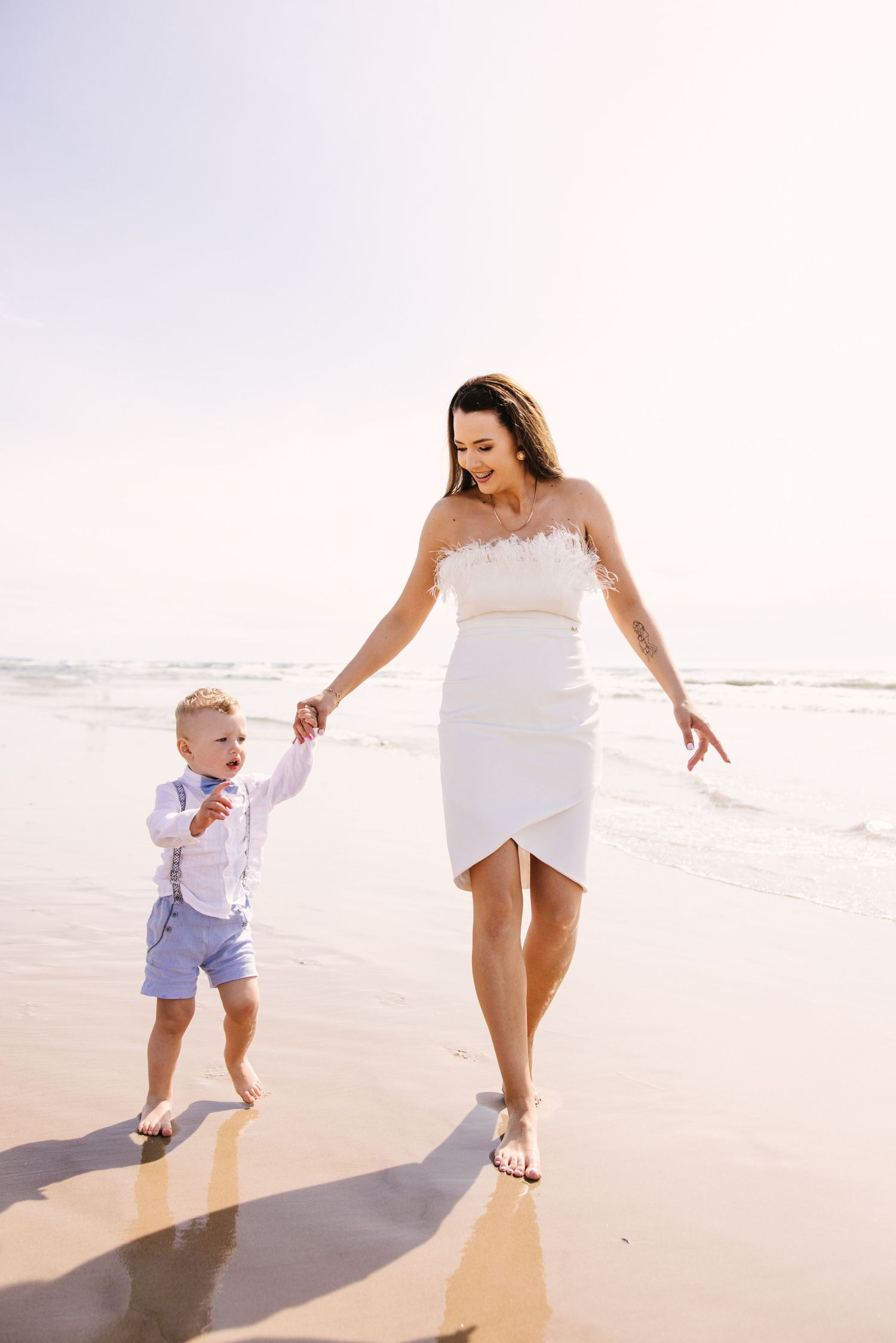 A carefree moment walking along the shoreline on a bright sunny beach day.