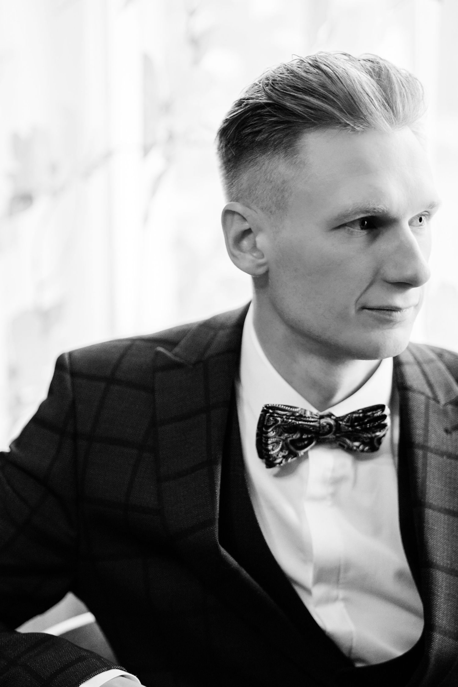 Black and white portrait series showing a stylish bow tie and formal attire in close-up details.