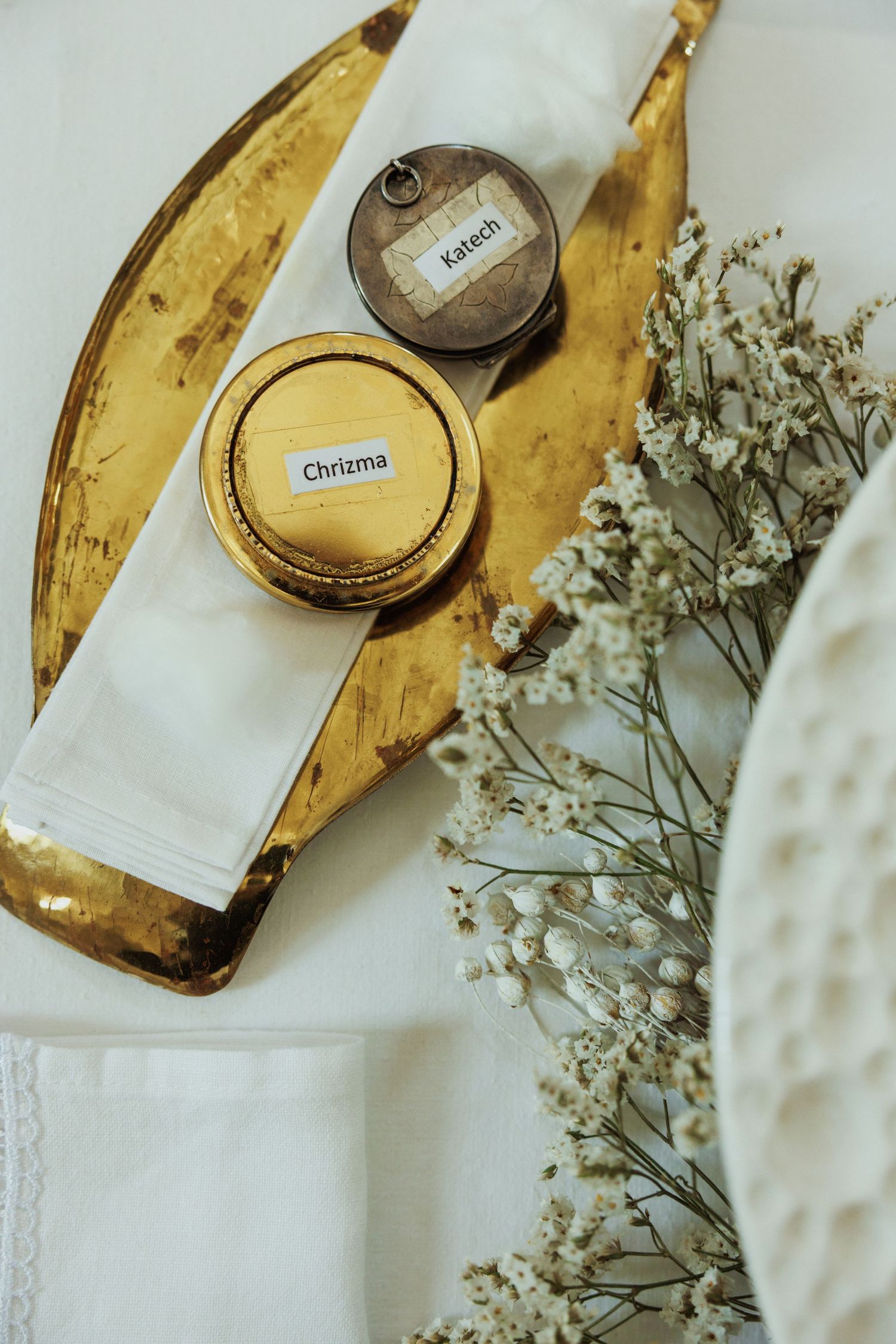 Delicate baby's breath flowers arranged beside a vintage pocket watch on a white textured surface.