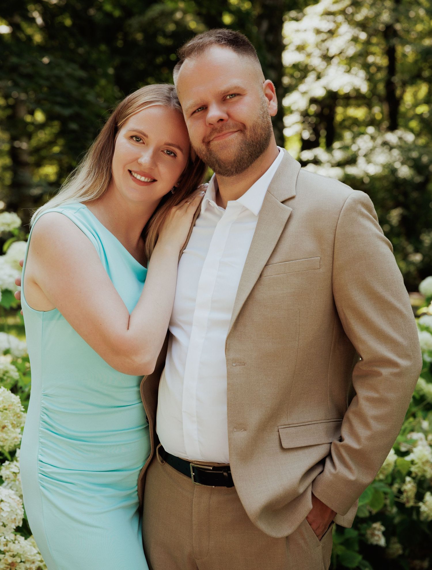 A couple shares tender moments in a series of outdoor photos with sunlit trees in the background, wearing mint and tan.