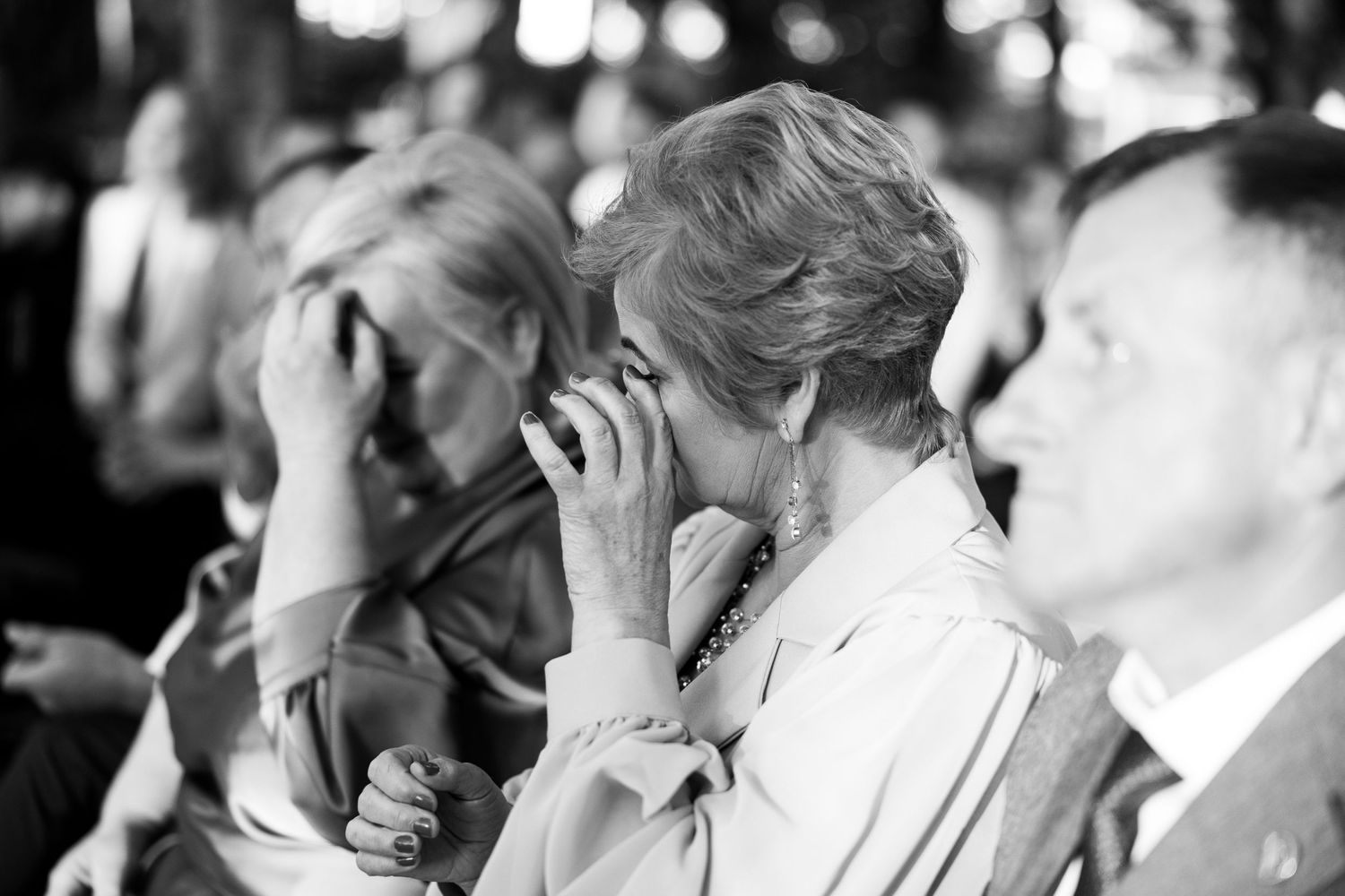 Black and white candid shots of wedding guests showing emotional reactions during ceremony.