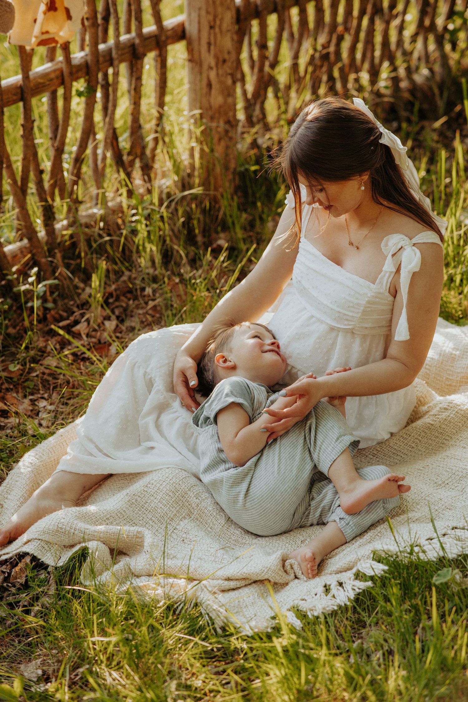 Tender moment captured on a blanket in a grassy garden setting.