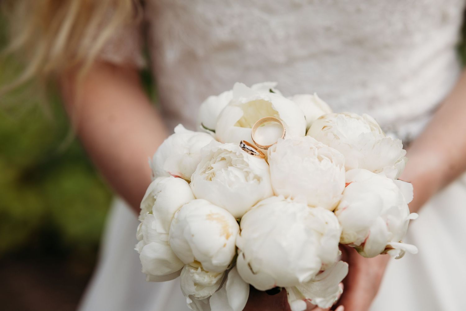 A series of white peony bouquets being held against different backgrounds in a wedding setting.