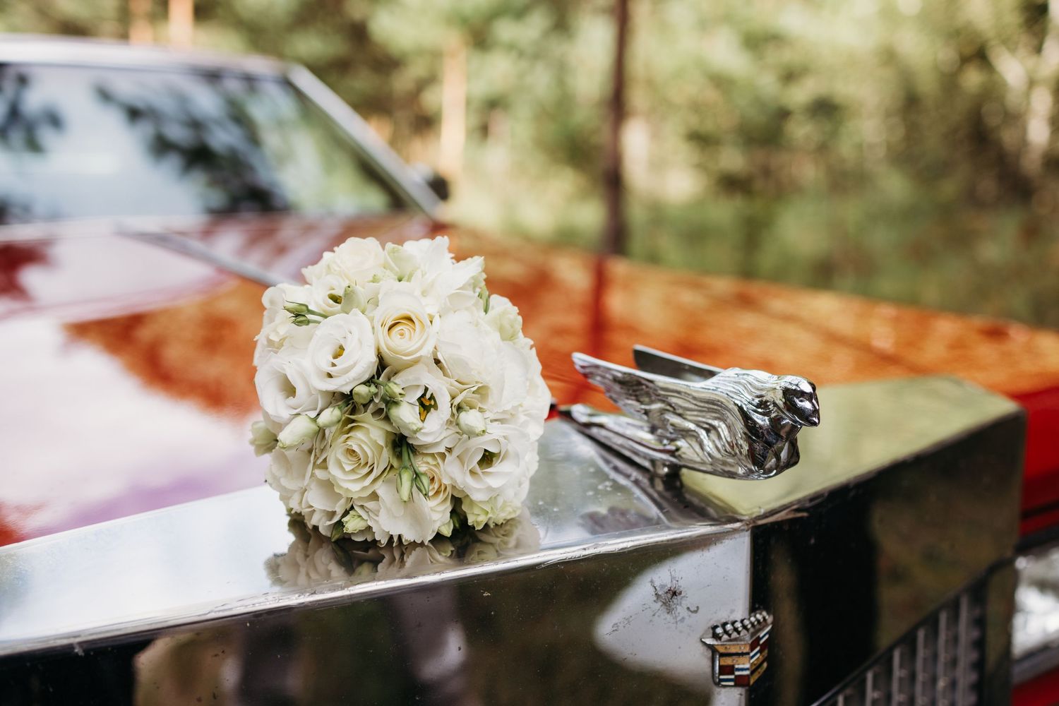 White bridal bouquet resting on dark surface with elegant floral arrangement.