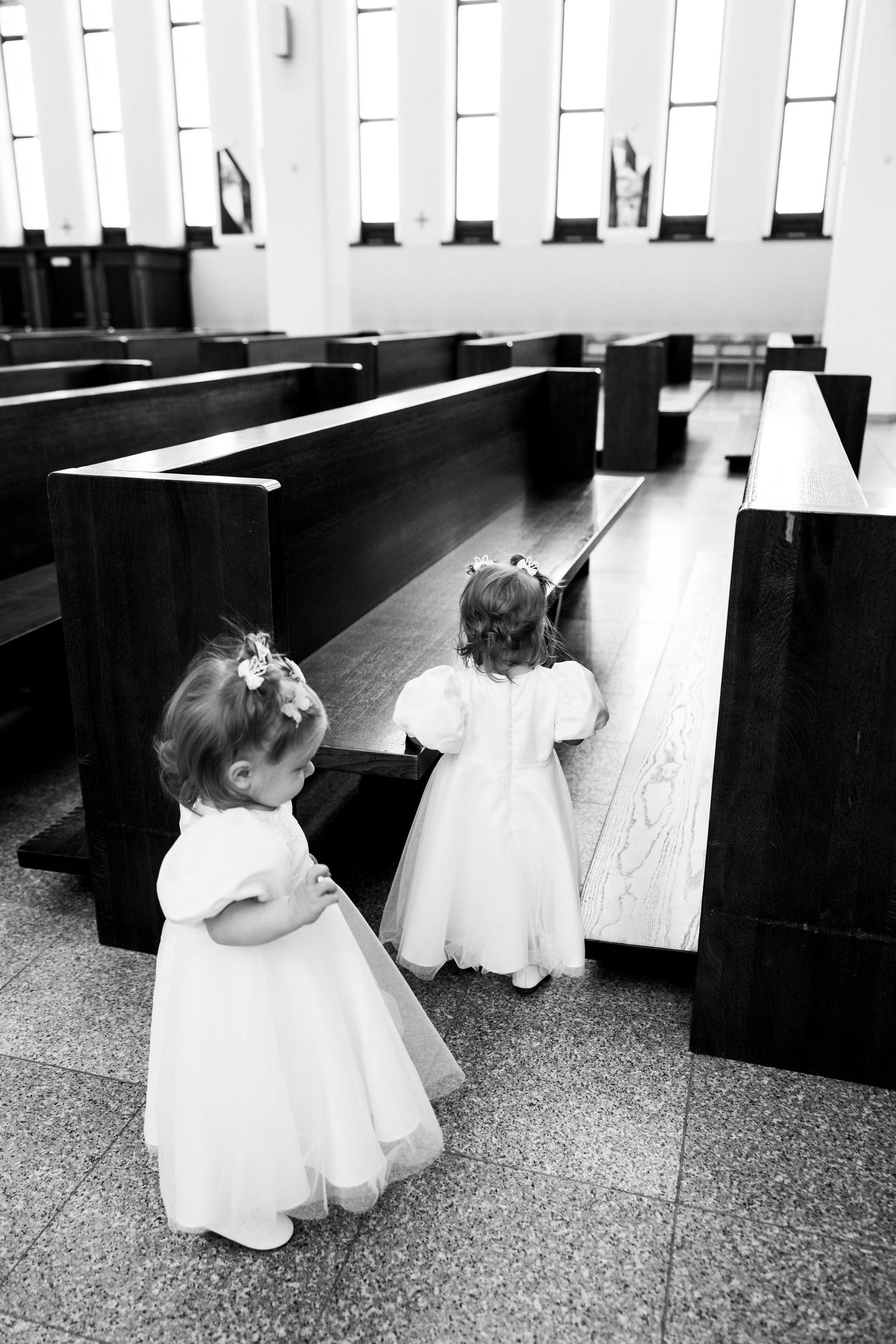 Black and white photos capturing intimate moments between adults and a small child in formal attire at a church.