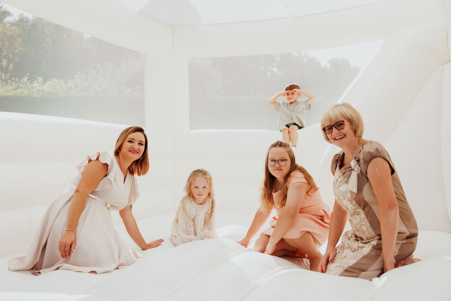 Candid interactions photographed in all-white studio environment showing joyful expressions.