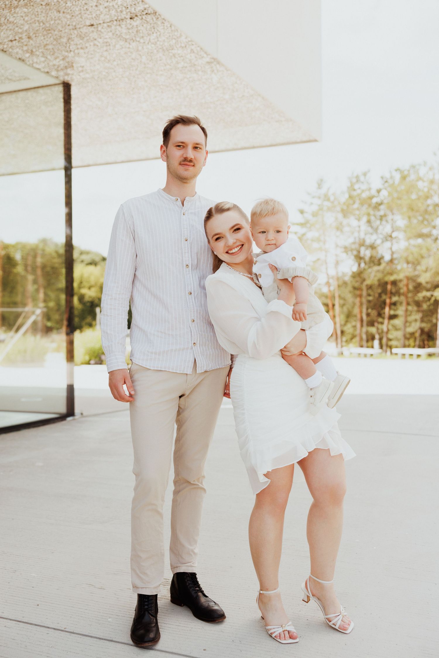 A sunny outdoor gathering with people dressed in light neutral colors on a bright patio.
