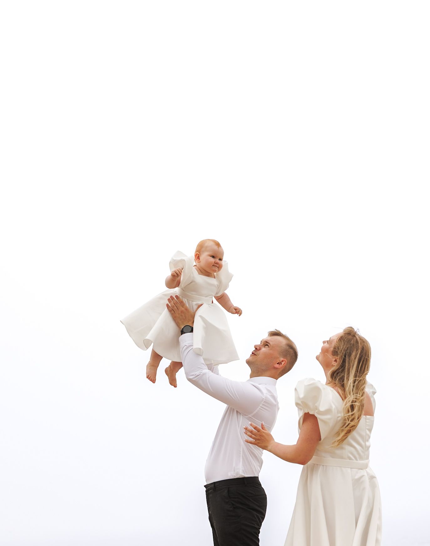 A joyful family moment captured against a bright white sky.