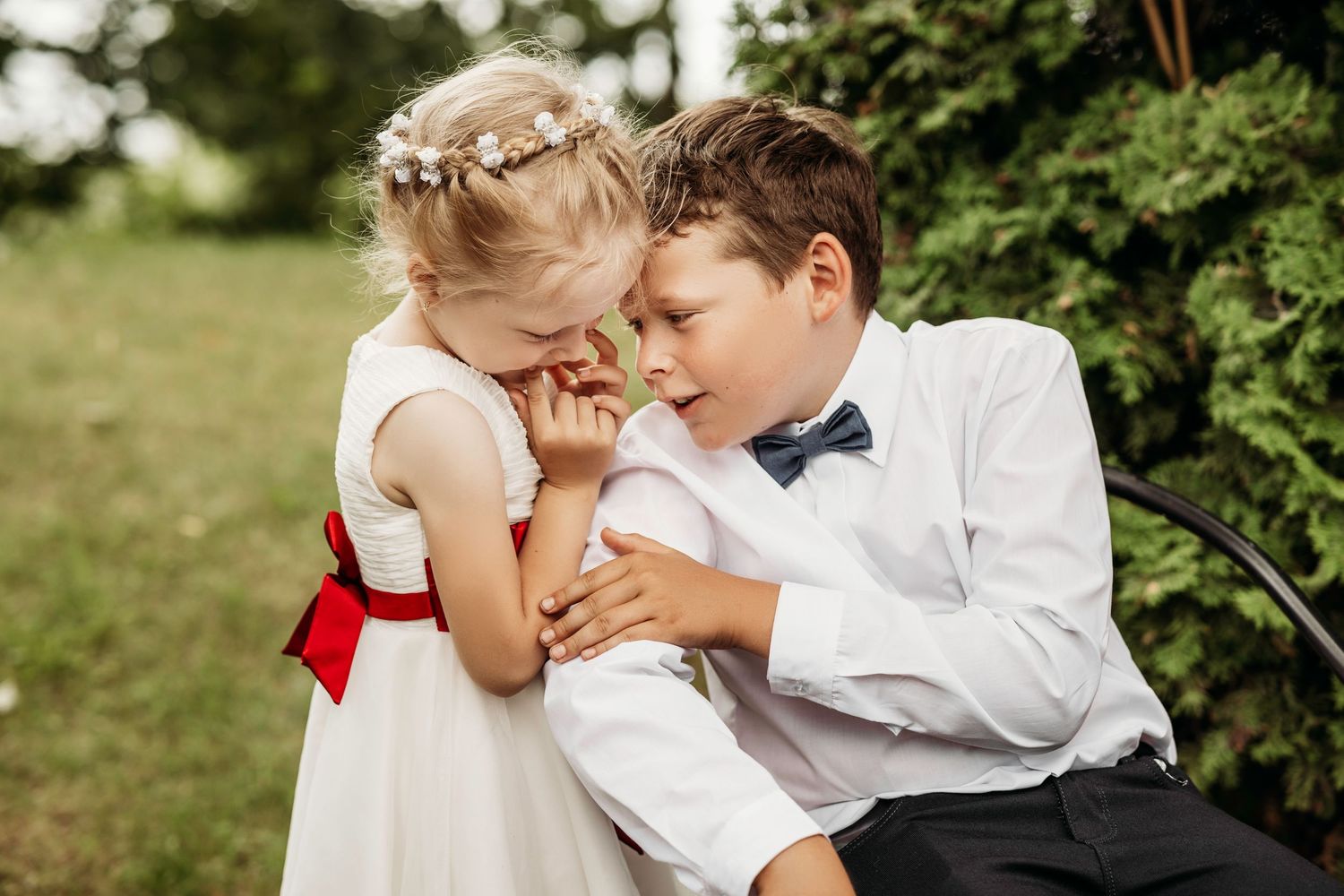 Intimate outdoor wedding moment with white floral decor and greenery in a garden setting.