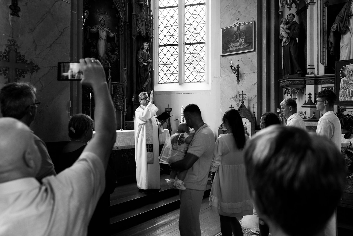 A wedding ceremony takes place in a church with guests watching the couple at the altar.