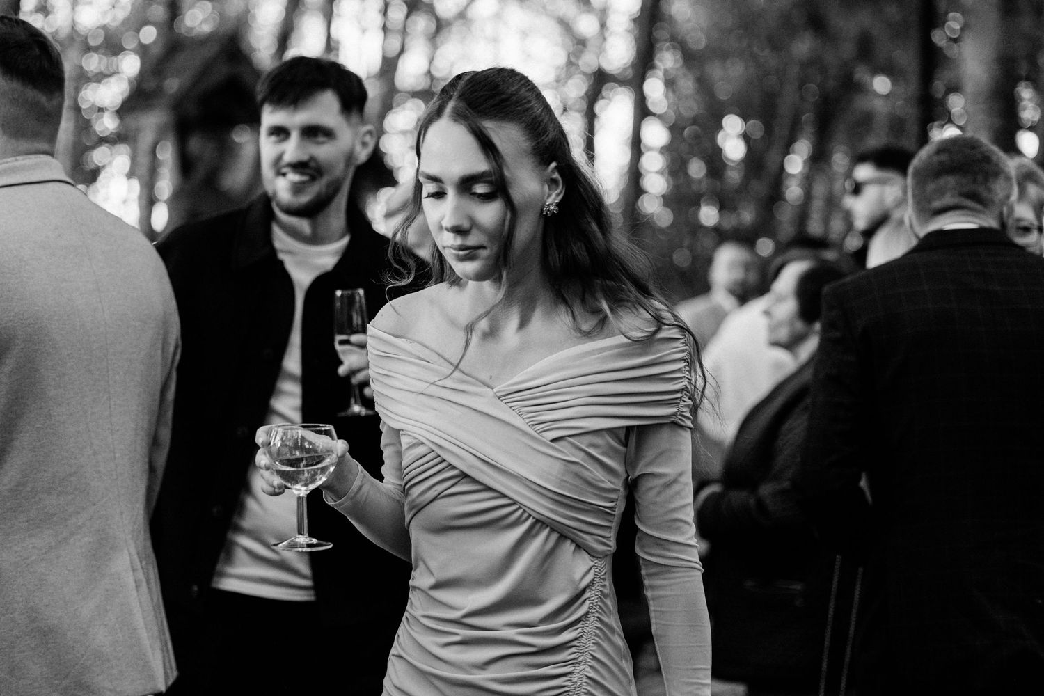 Black and white candid moments captured during an elegant outdoor celebration.