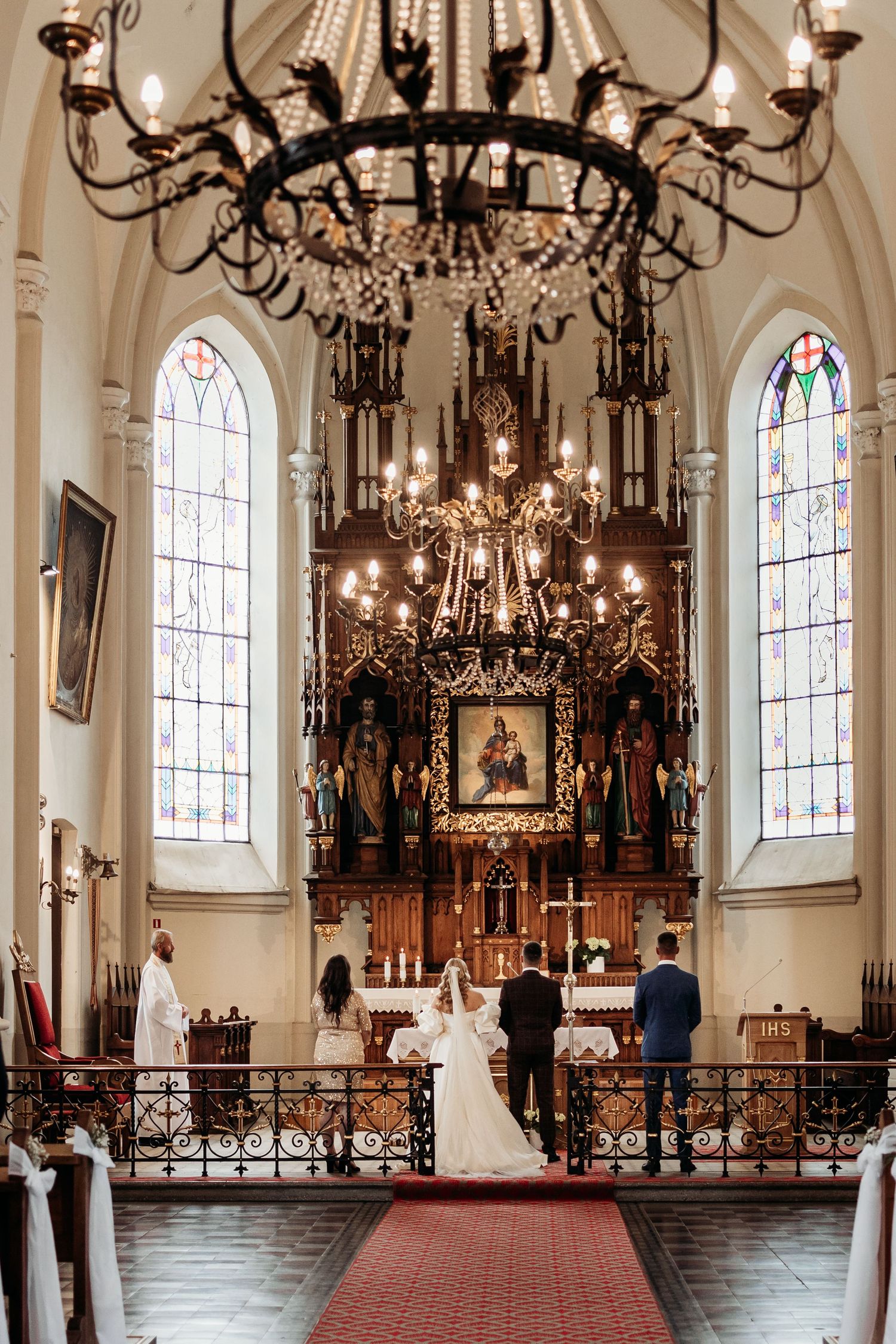 Panoramic view of an elegant church interior with ornate chandeliers, stained glass windows and decorative altar.