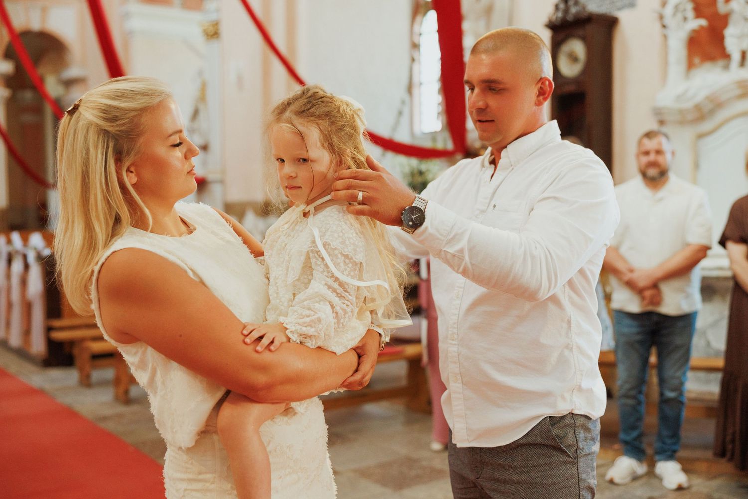 A couple dances together at their wedding reception while guests watch in the background.