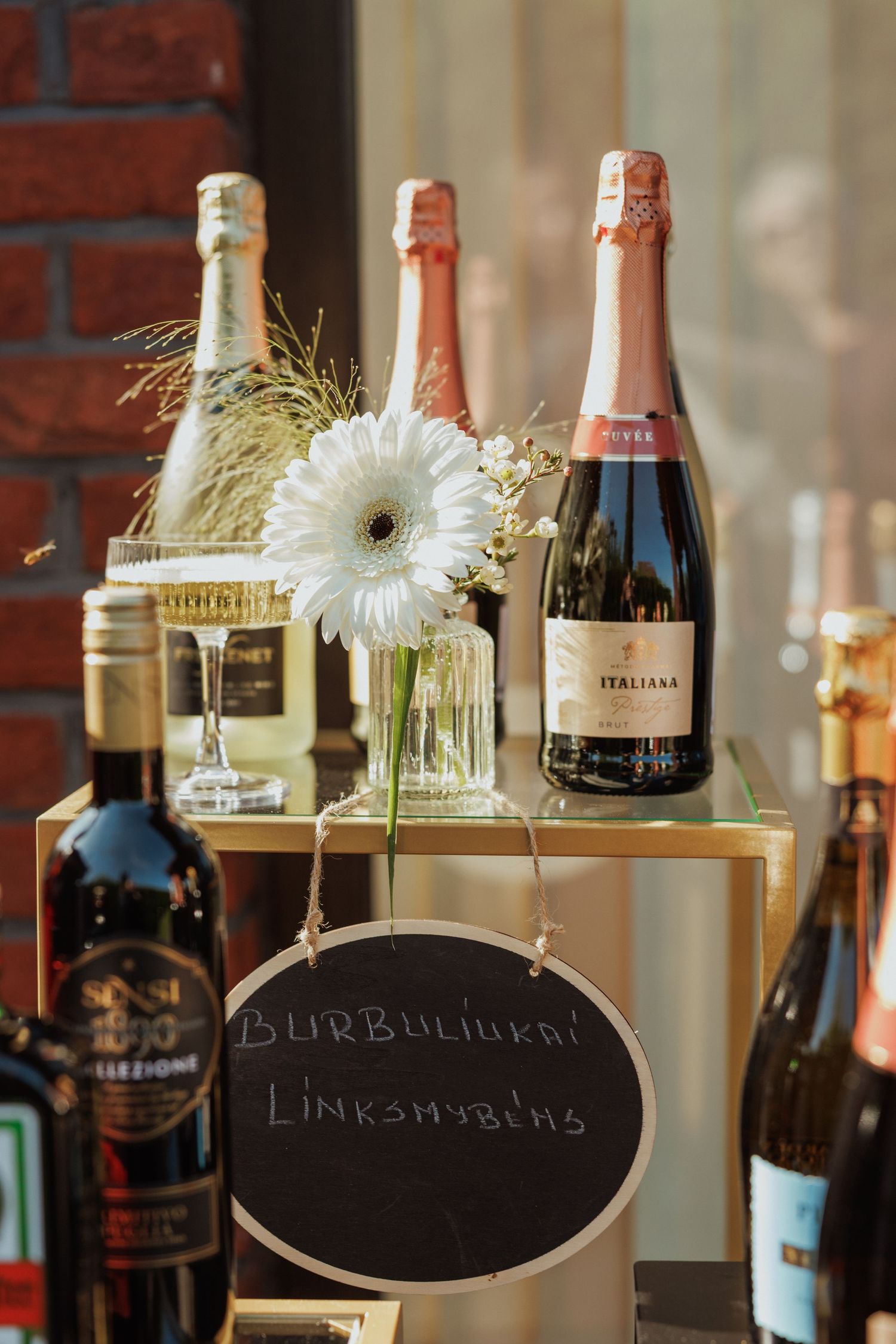 Champagne bottles and floral decorations displayed with a chalkboard sign.