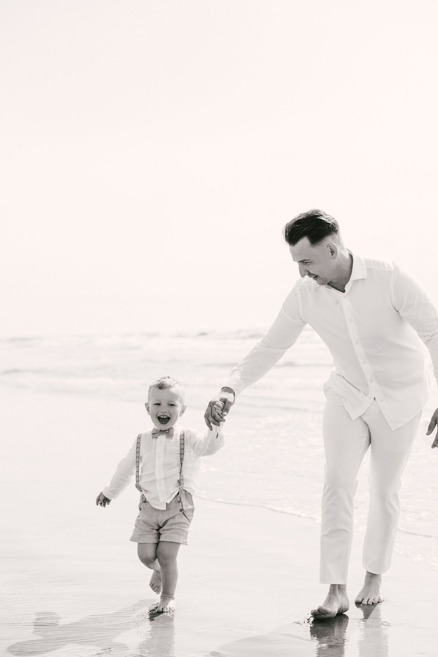 Black and white beach photography sequence showing playful moments in the sand.