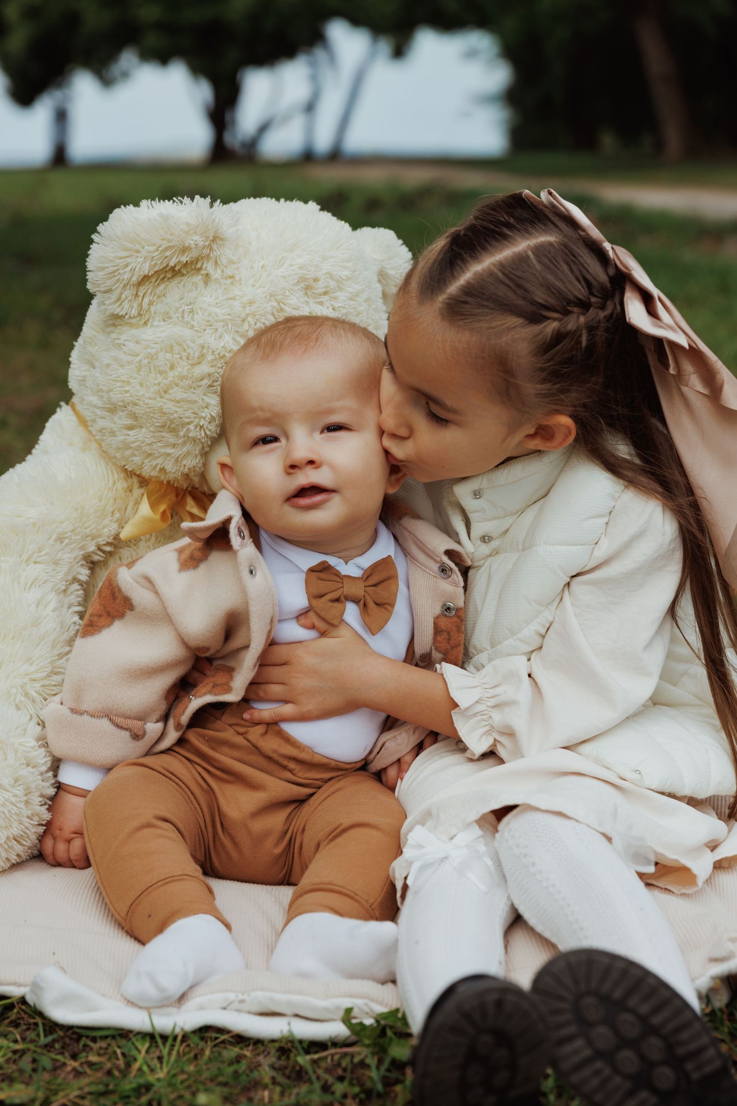 Sweet outdoor photoshoot showing tender moments between two people lying on cream colored blankets.