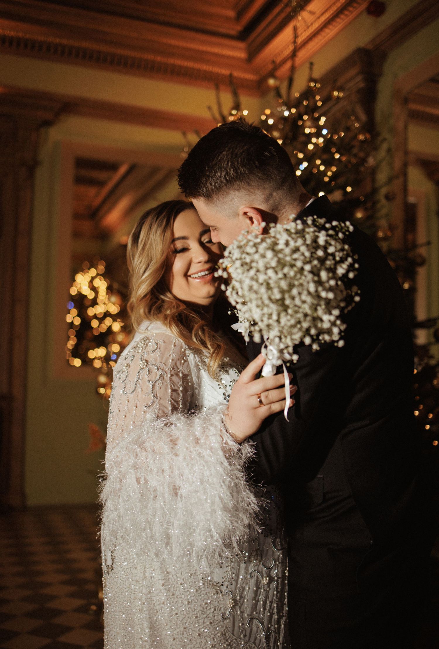 Intimate wedding moment captured in warm lighting with Christmas decorations.