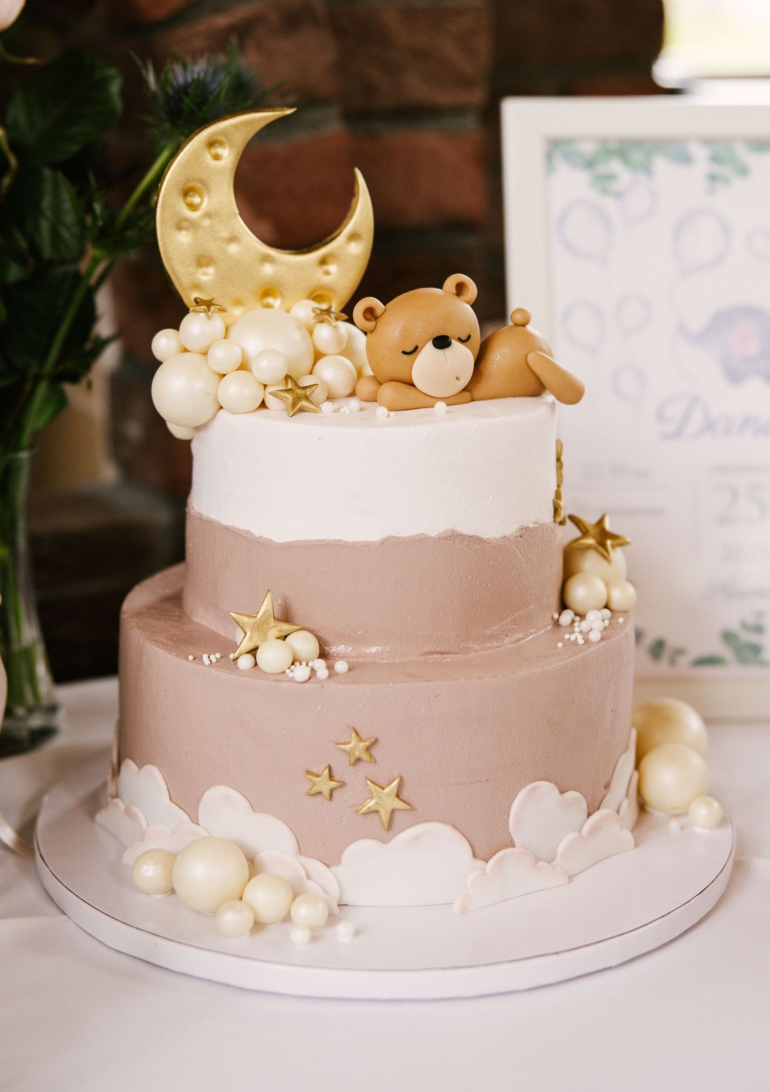 Dreamy pink cake decorated with gold stars, clouds, and a crescent moon topper.