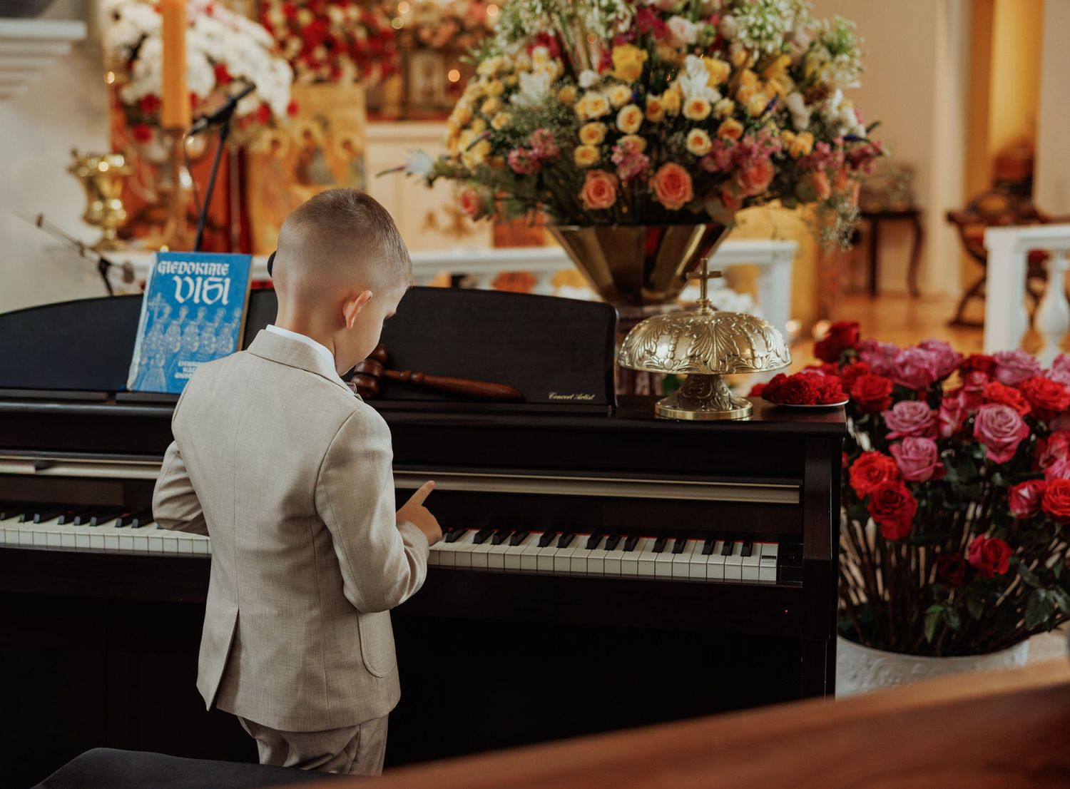A piano keyboard sits in an elegant room decorated with floral arrangements and golden accents.