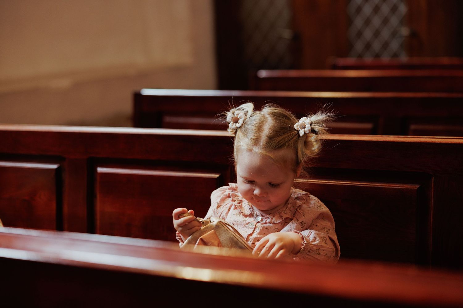 Wooden church pews in a row with warm lighting and traditional interior details.